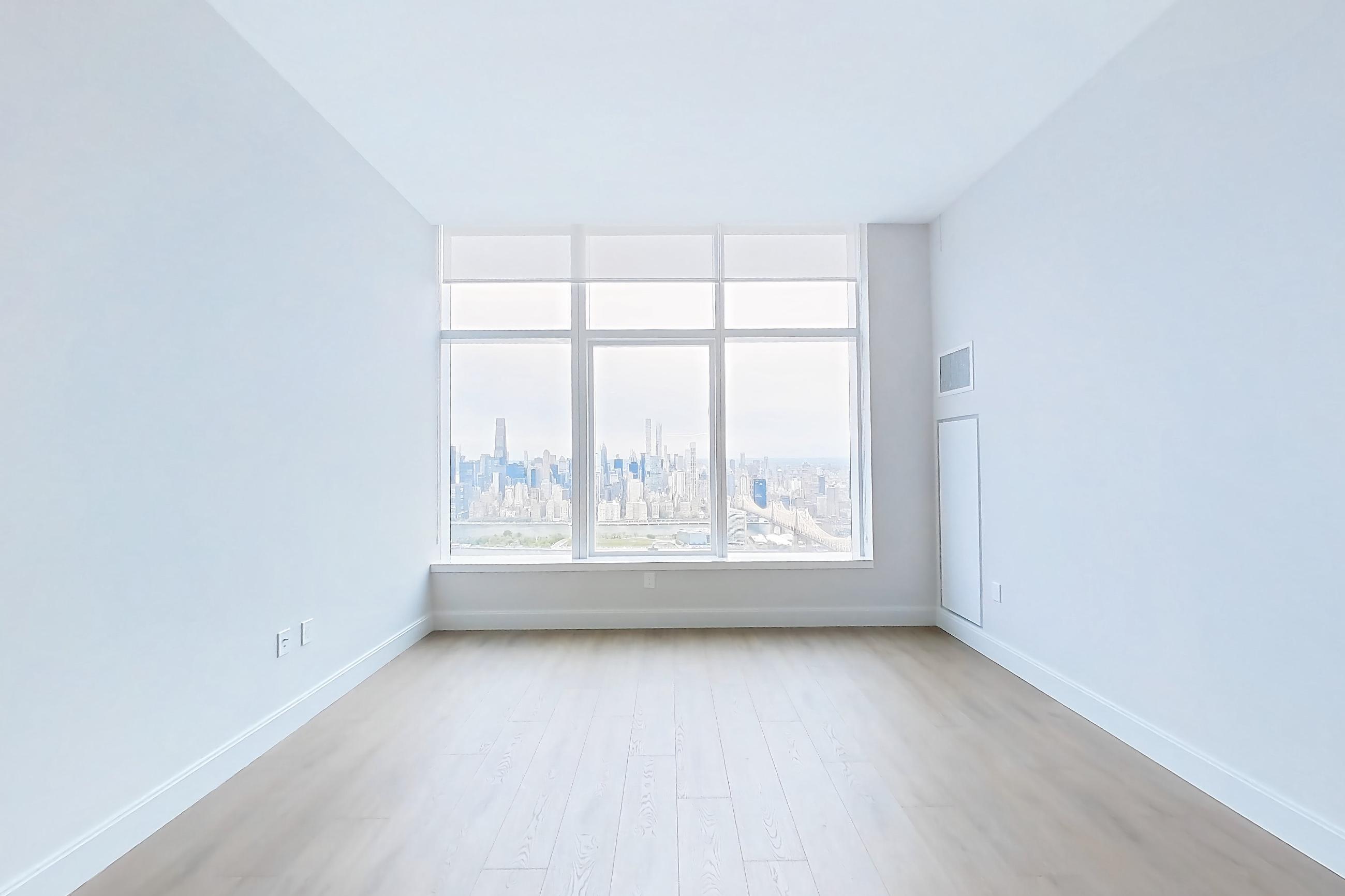 Living space with city view and light wood-finish flooring, Apartment PH1H at Lumen