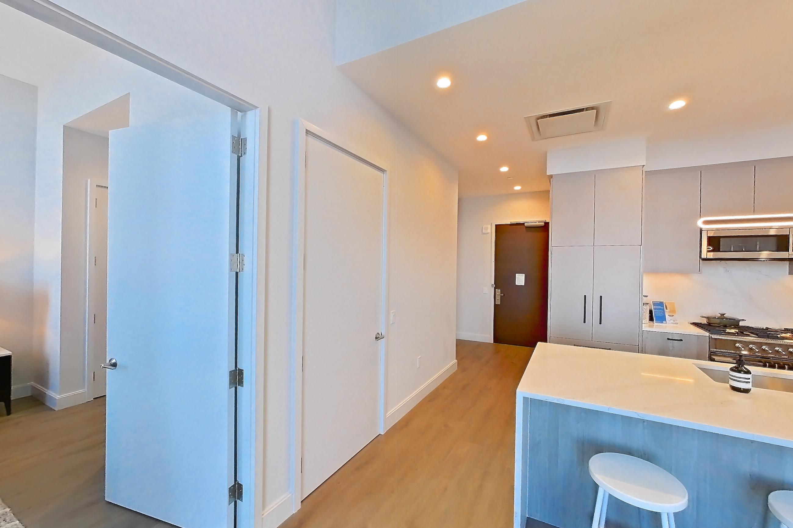 Living space with dark wood-finish flooring, Apartment PH2A at Lumen