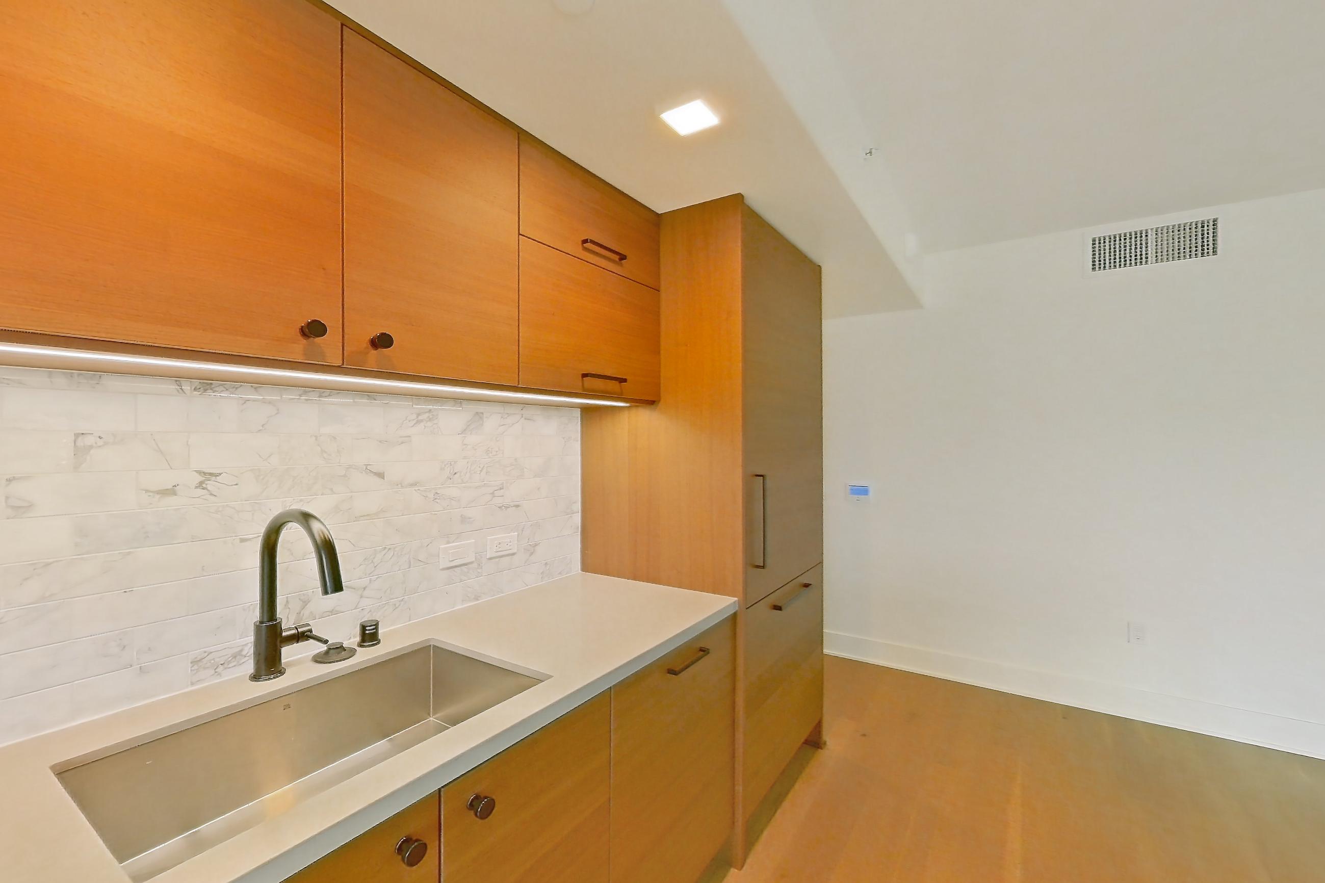 Kitchen with cooktop, gas cooktop, light countertops, light wood-finish flooring, oven/range, and stainless steel appliances, Apartment 418 at Konrad on the Park