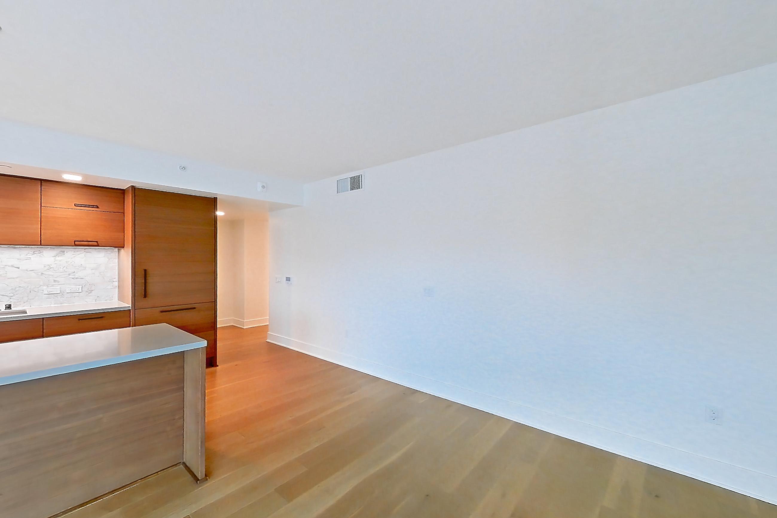 Living room with cooktop, gas cooktop, light countertops, light wood-finish flooring, oven/range, and stainless steel appliances, Apartment 418 at Konrad on the Park