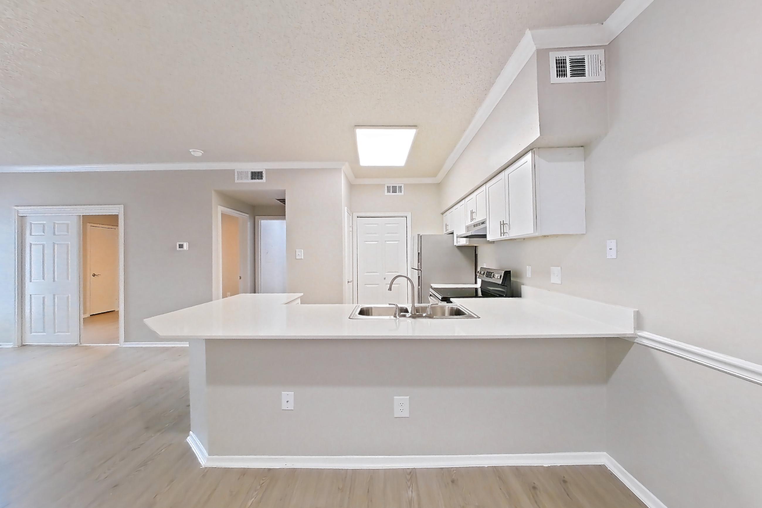 Dining room with electric range, light countertops, light wood-finish flooring, oven/range, range hood, and stainless steel appliances, Apartment 228 at Museo and Channings Mark