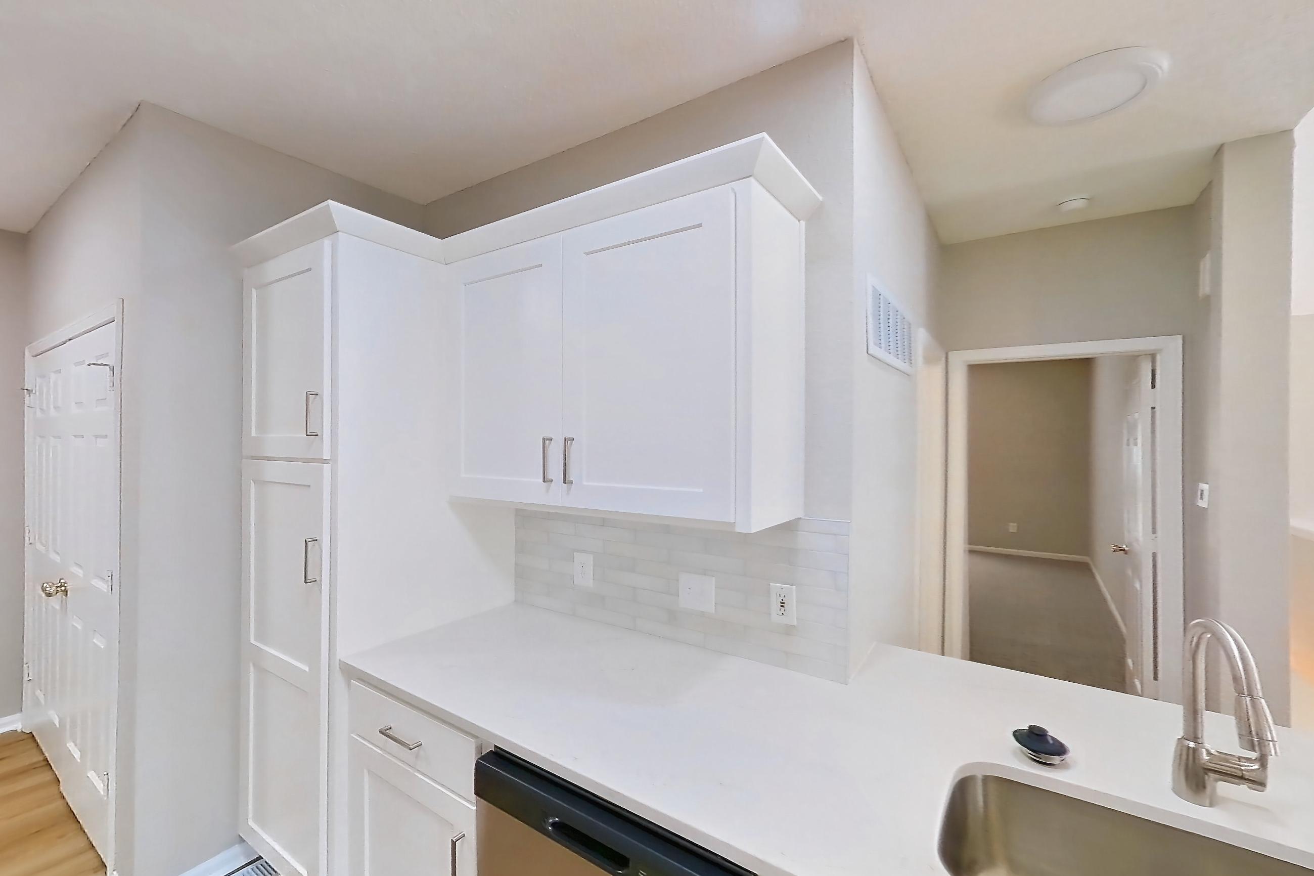 Kitchen with dishwasher, electric range, light countertops, light stone countertops, light wood-finish flooring, microwave, oven/range, refrigerator, and stainless steel appliances, Apartment Walkout Townhome at Bradford Pointe