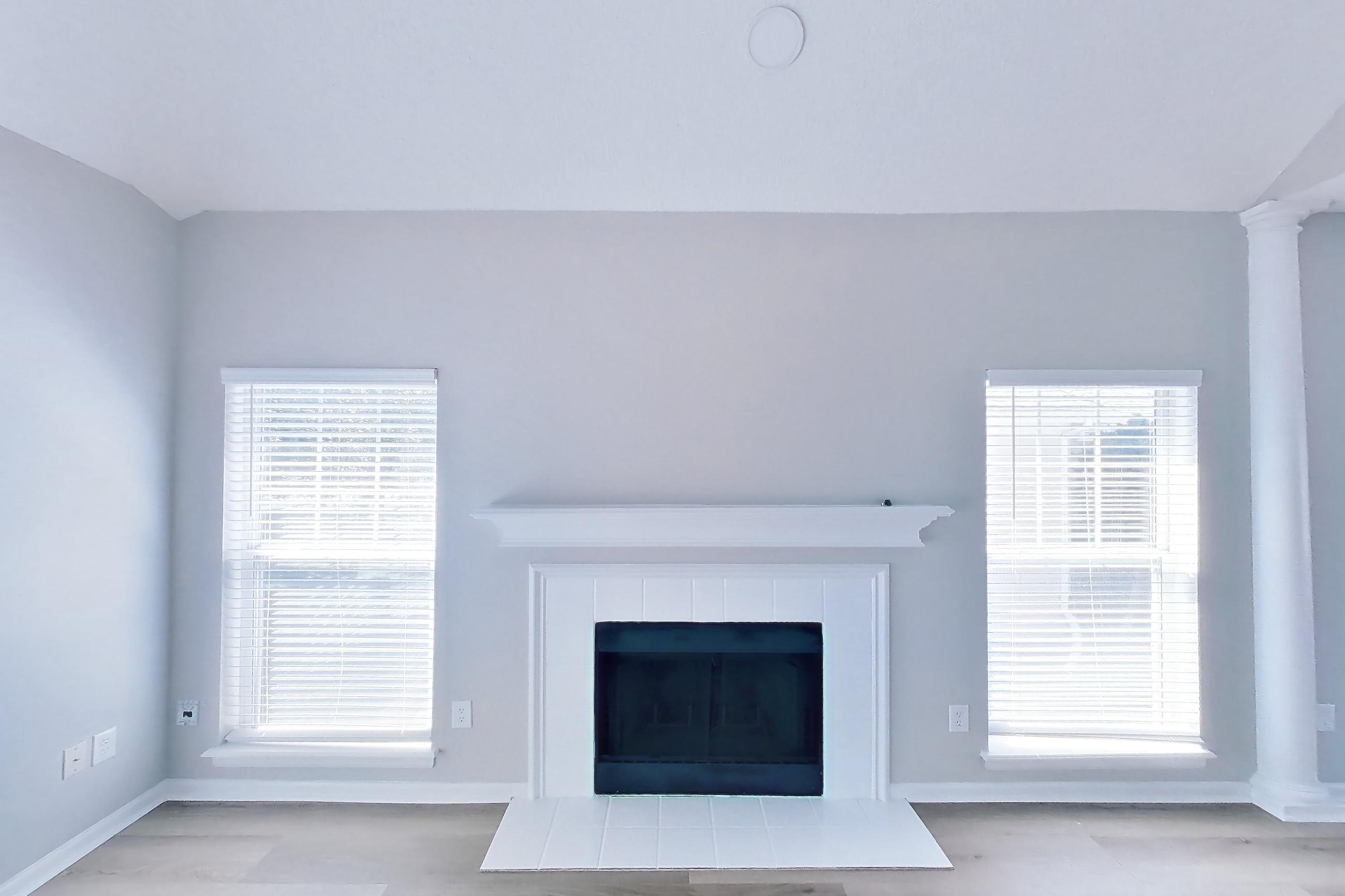 Living room with fireplace, light wood-finish flooring, oven/range, and stainless steel appliances, Apartment Walkout Townhome at Bradford Pointe