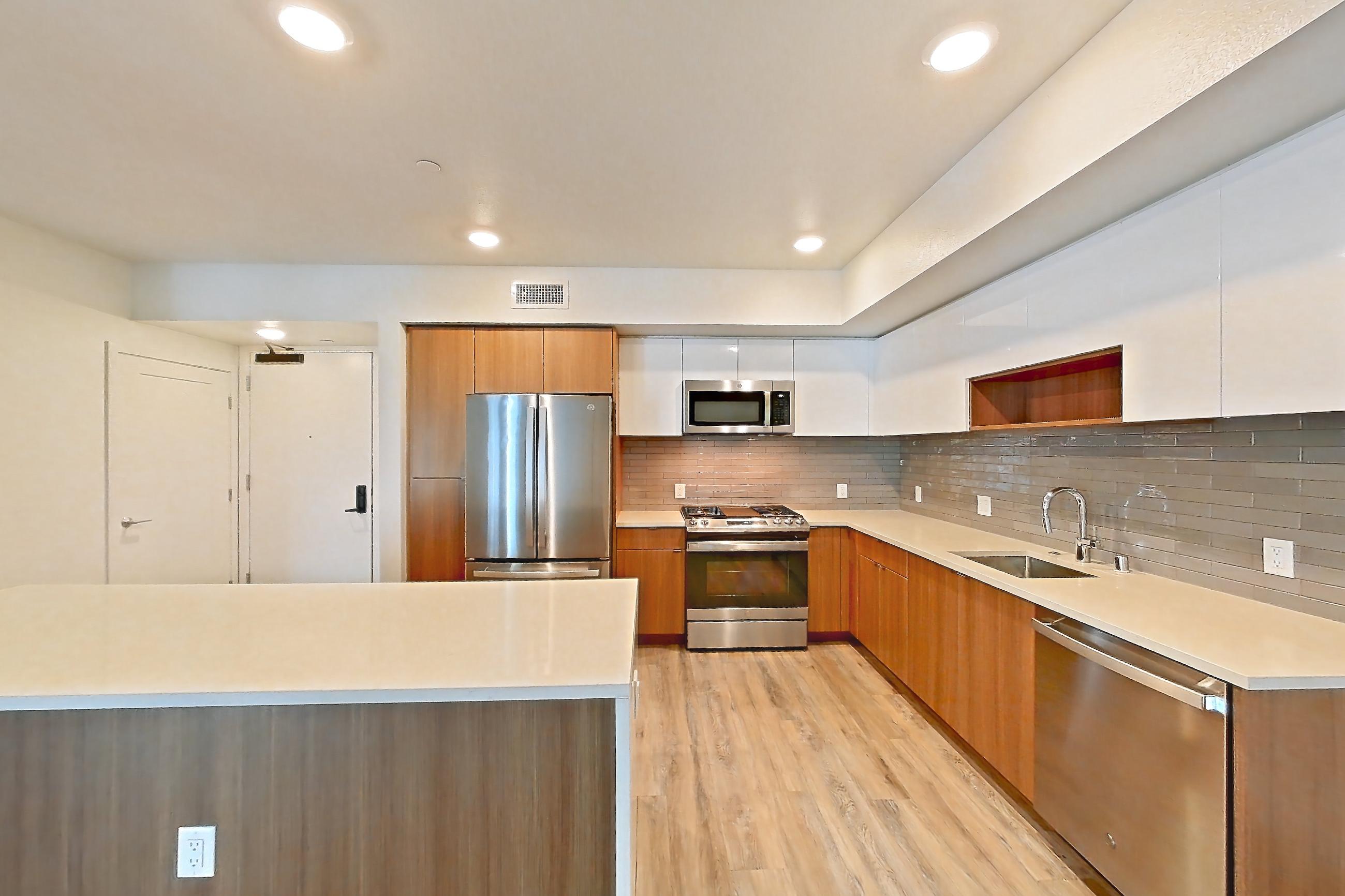 Dining room with dishwasher, gas range, light countertops, light stone countertops, light wood-finish flooring, microwave, oven/range, refrigerator, and stainless steel appliances, Apartment 503 at Assembly