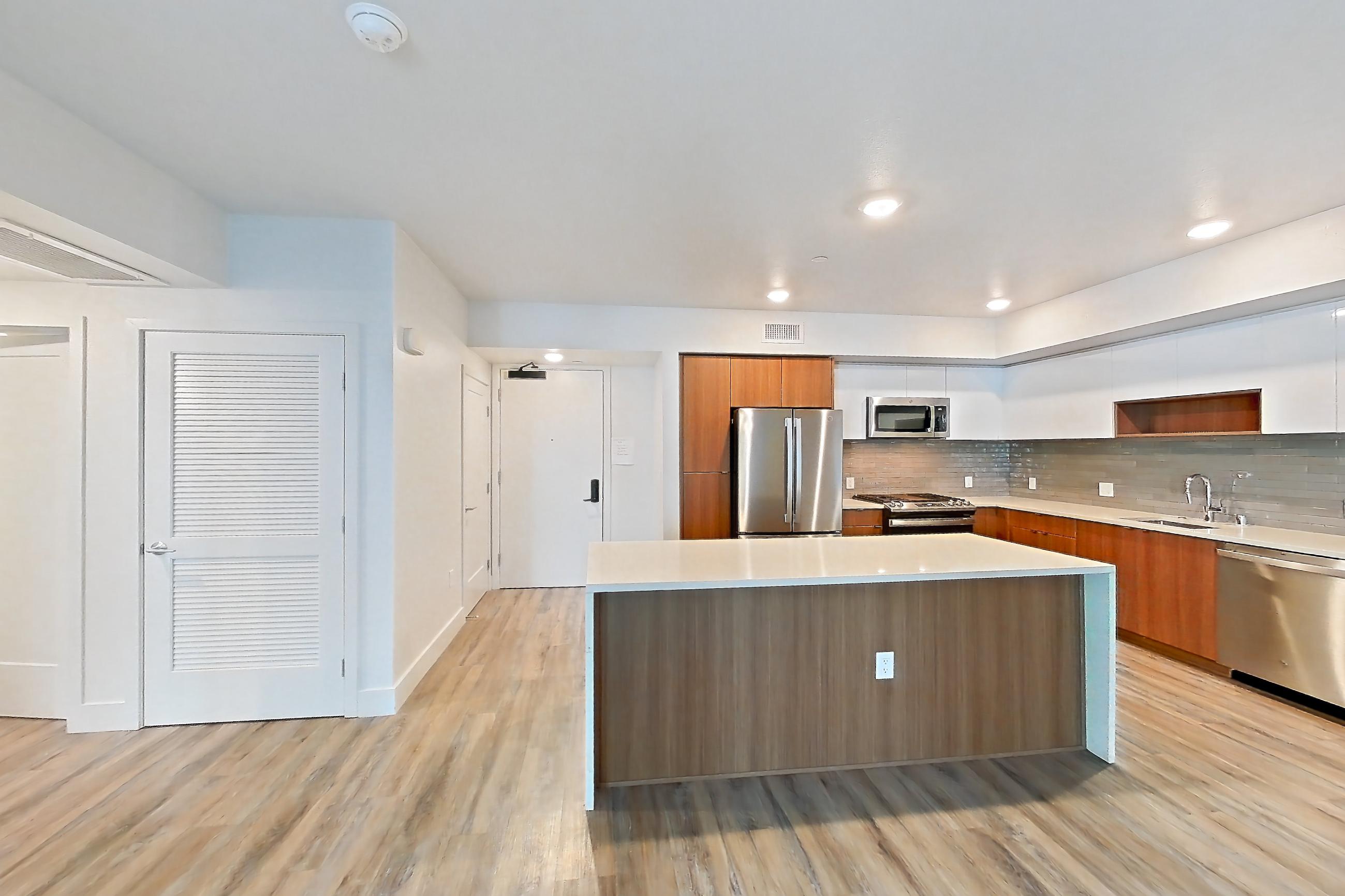 Living room with dishwasher, gas range, light countertops, light wood-finish flooring, oven/range, refrigerator, and stainless steel appliances, Apartment 503 at Assembly