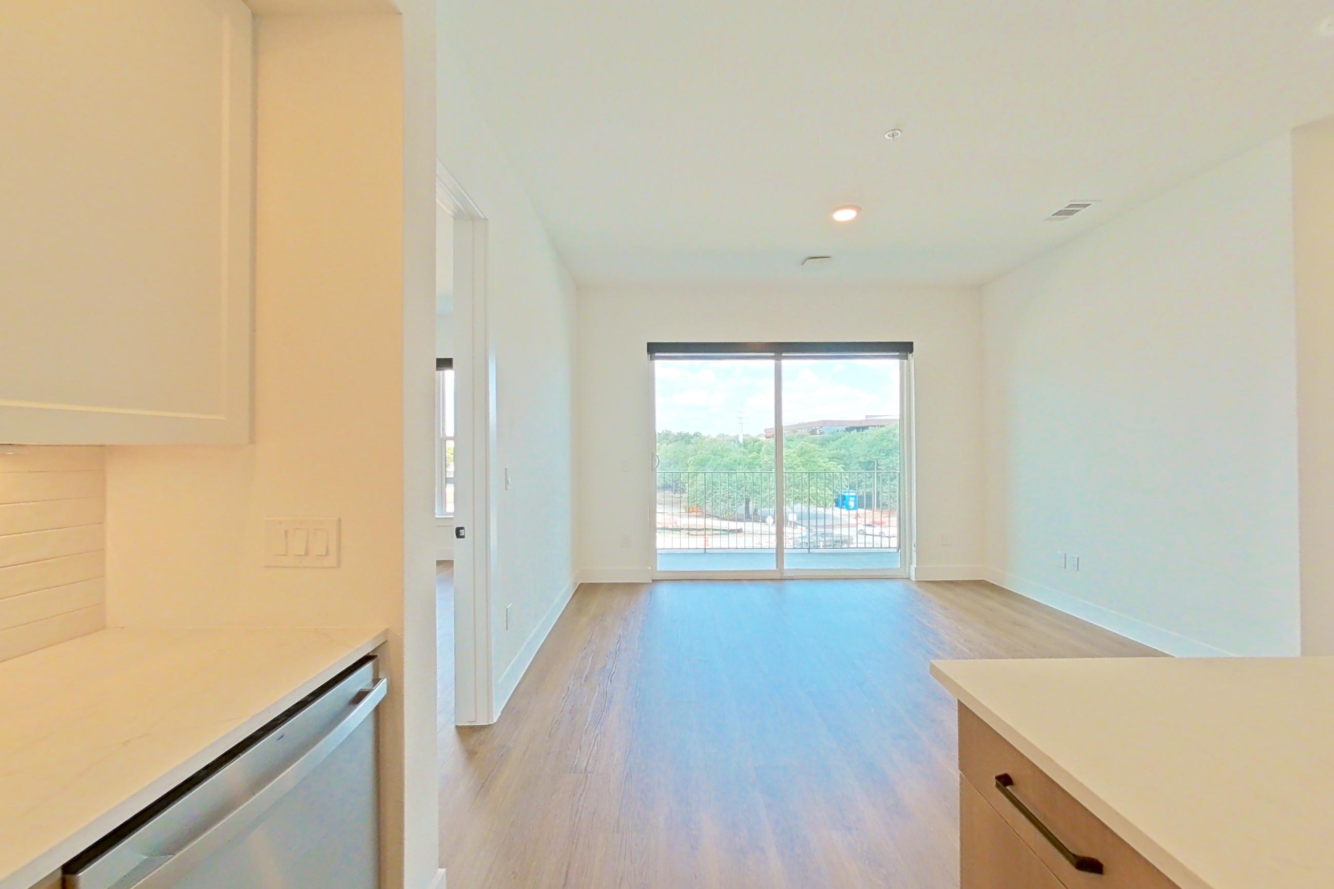 Kitchen with dishwasher, electric range, light stone countertops, light wood-finish flooring, and stainless steel appliances, Apartment 314 at The Watson