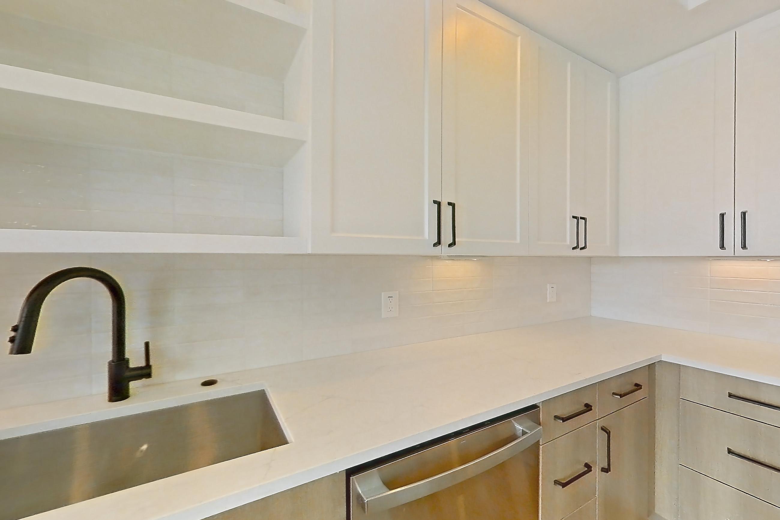 Kitchen with dishwasher, light stone countertops, light wood-finish flooring, refrigerator, and stainless steel appliances, Apartment 316 at The Watson