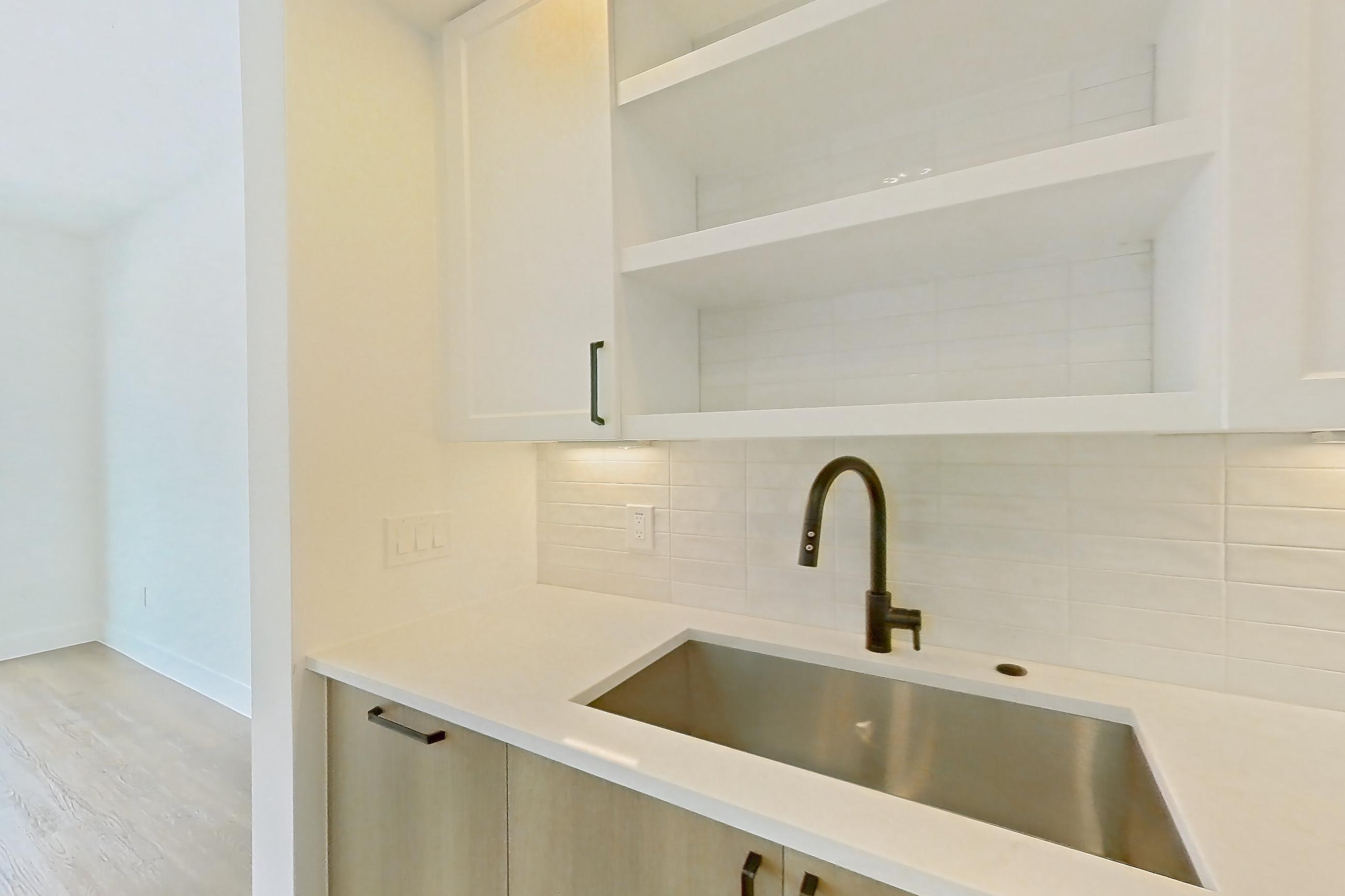 Kitchen with dishwasher, light stone countertops, light wood-finish flooring, and stainless steel appliances, Apartment 406 at The Watson