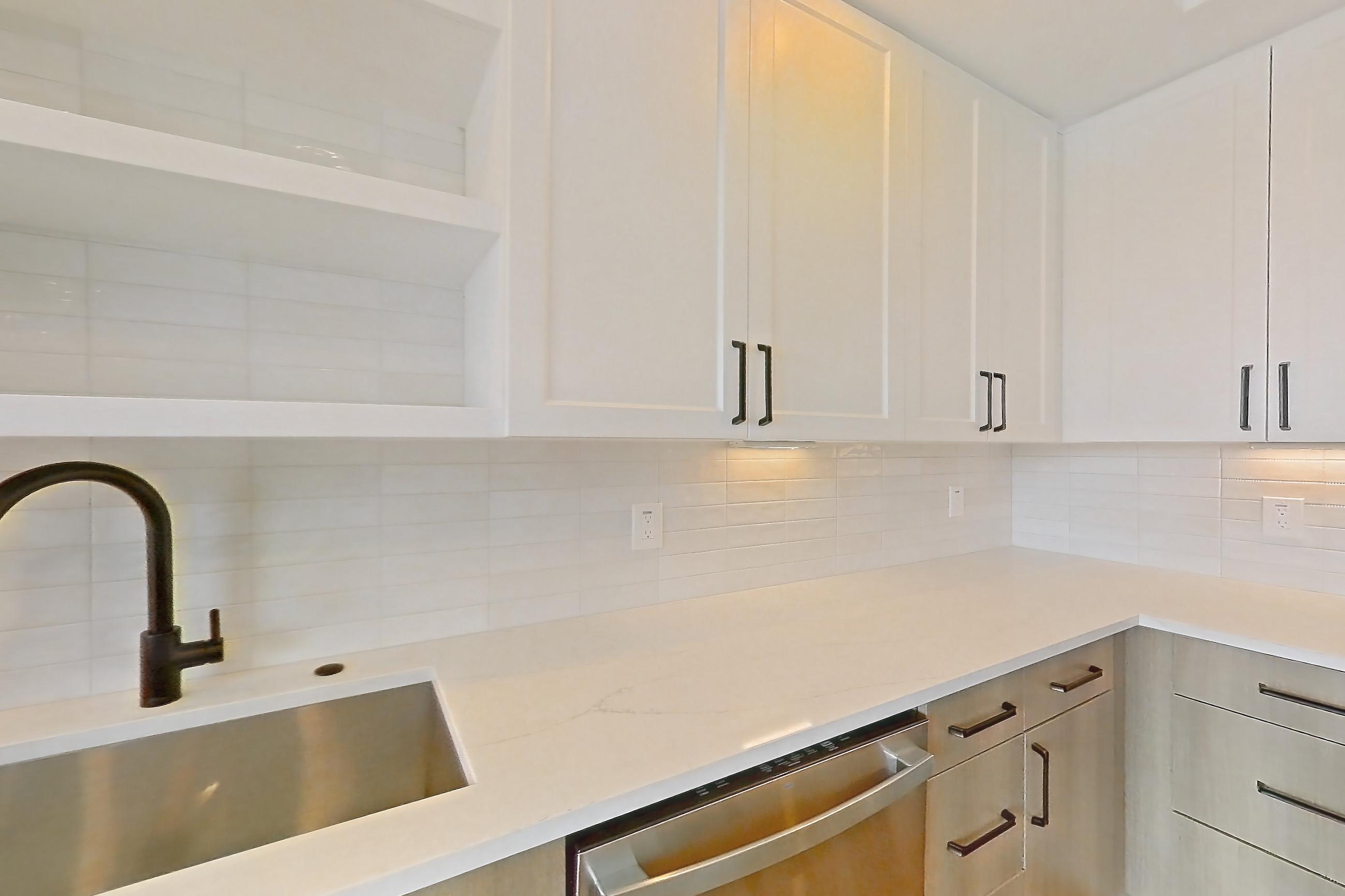 Kitchen with dishwasher, light stone countertops, light wood-finish flooring, refrigerator, and stainless steel appliances, Apartment 416 at The Watson