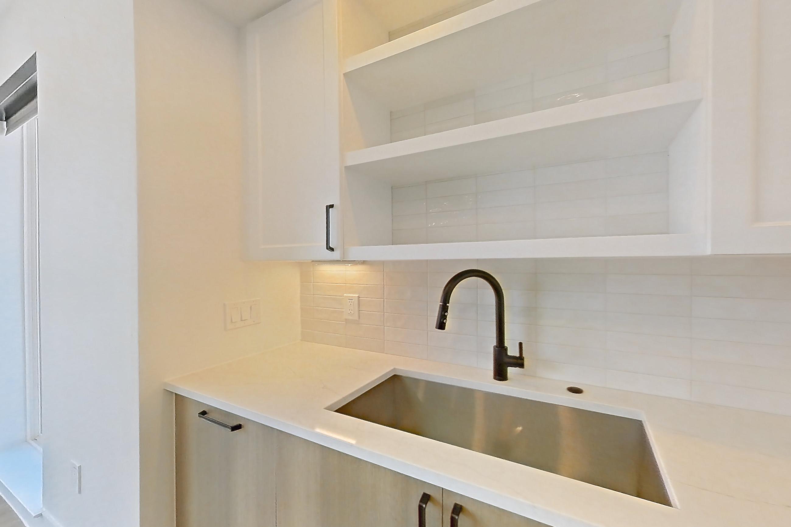 Kitchen with dishwasher, light stone countertops, light wood-finish flooring, refrigerator, and stainless steel appliances, Apartment 416 at The Watson