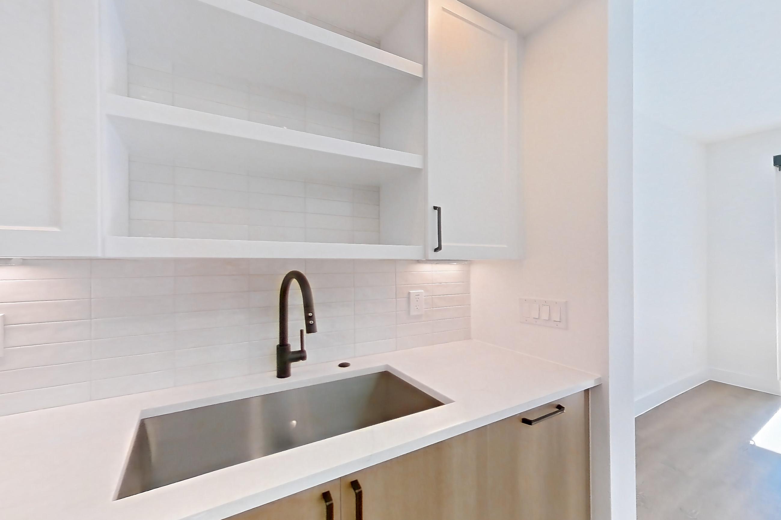 Kitchen with dishwasher, light stone countertops, light wood-finish flooring, and stainless steel appliances, Apartment 503 at The Watson