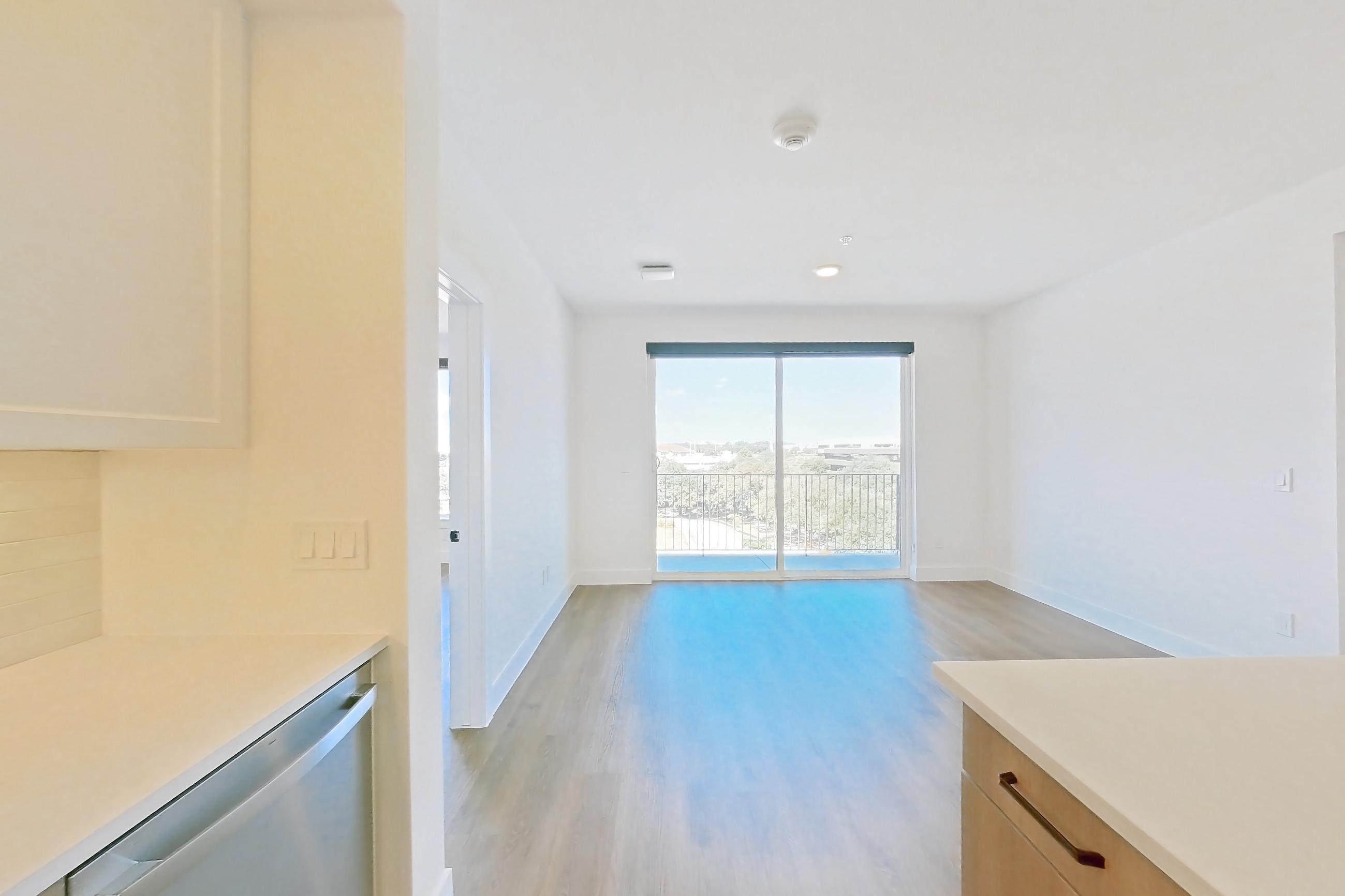 Kitchen with dishwasher, electric range, light stone countertops, light wood-finish flooring, oven/range, and stainless steel appliances, Apartment 510 at The Watson