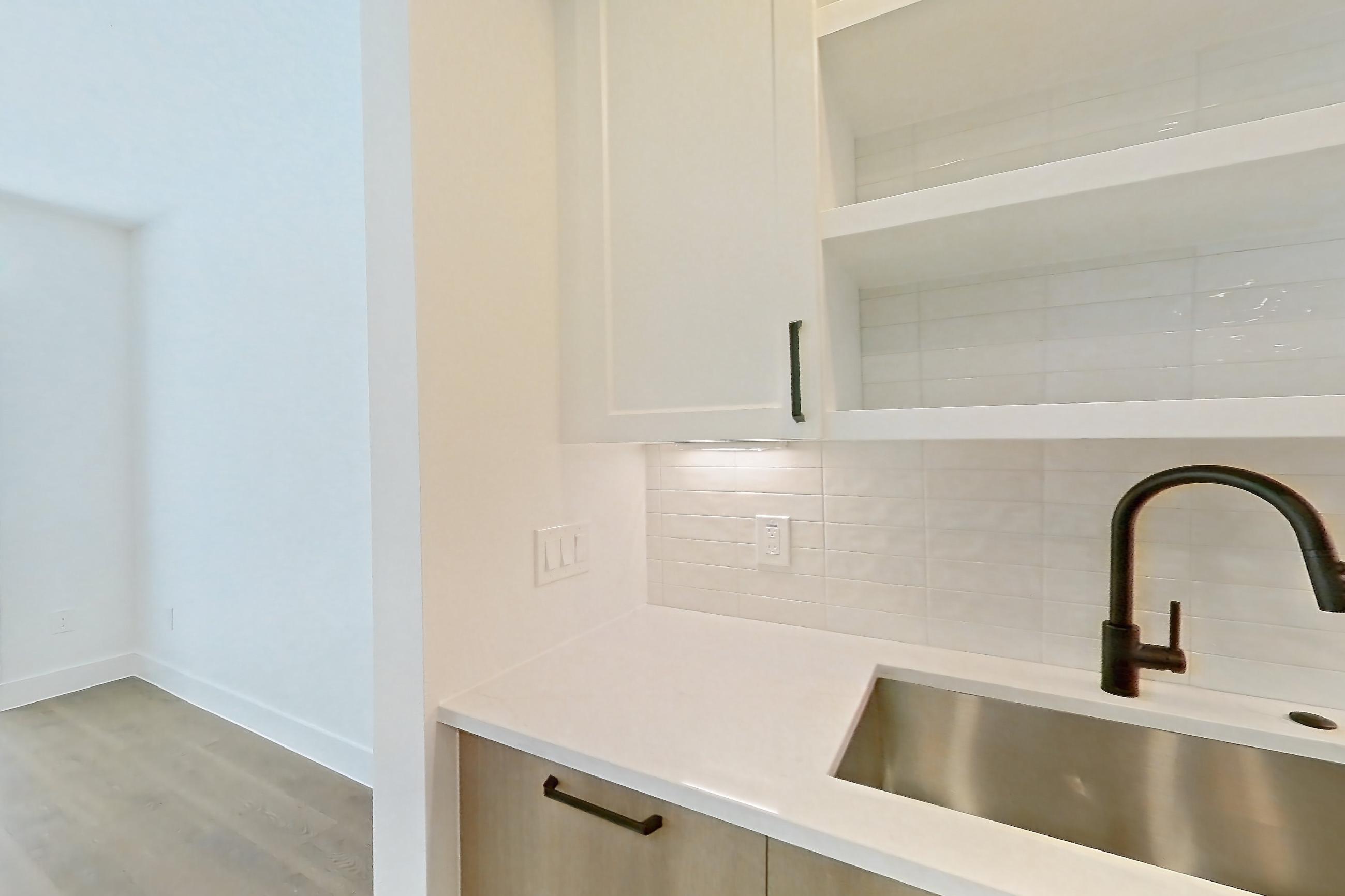 Kitchen with light stone countertops and light wood-finish flooring, Apartment 515 at The Watson