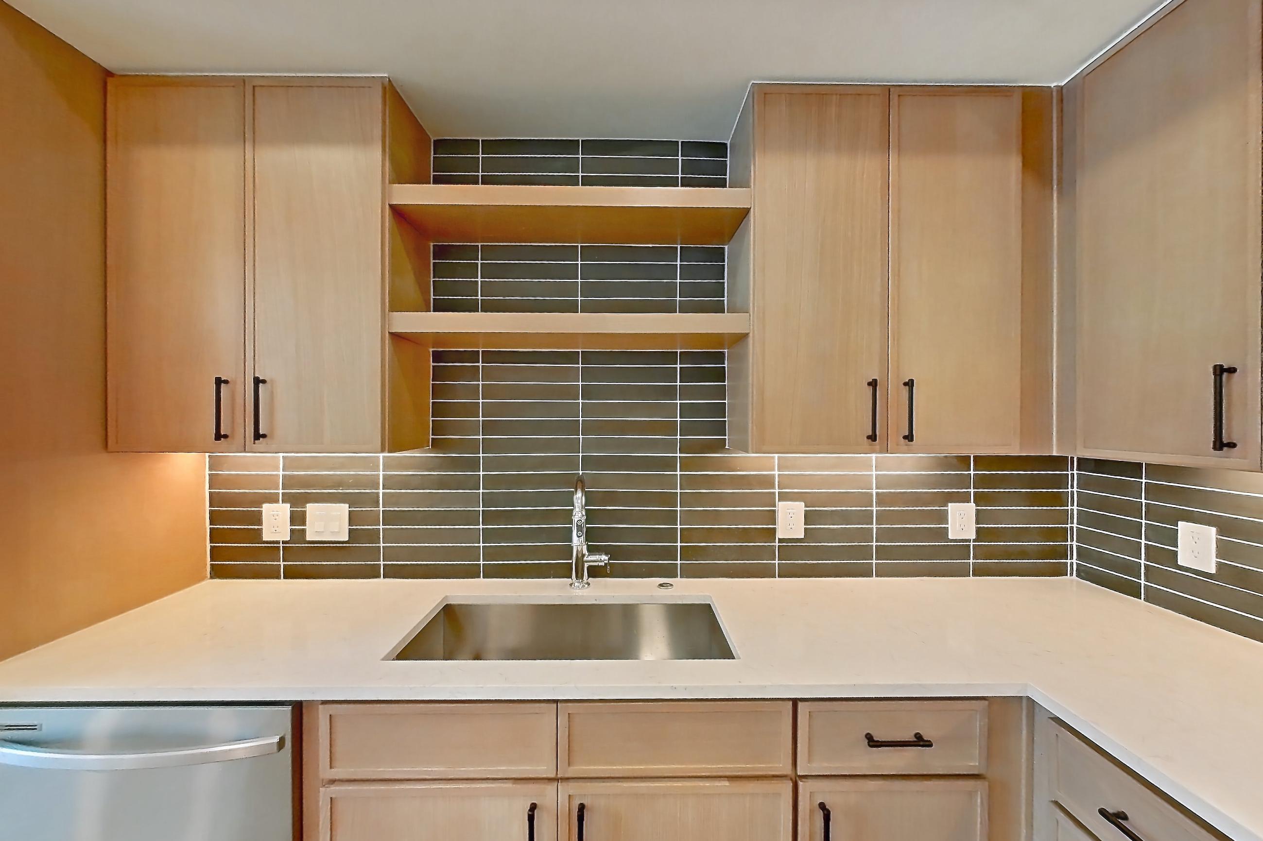 Kitchen with dishwasher, electric range, light countertops, light stone countertops, light wood-finish flooring, oven/range, refrigerator, and stainless steel appliances, Apartment 1104 at Cortland Galleria