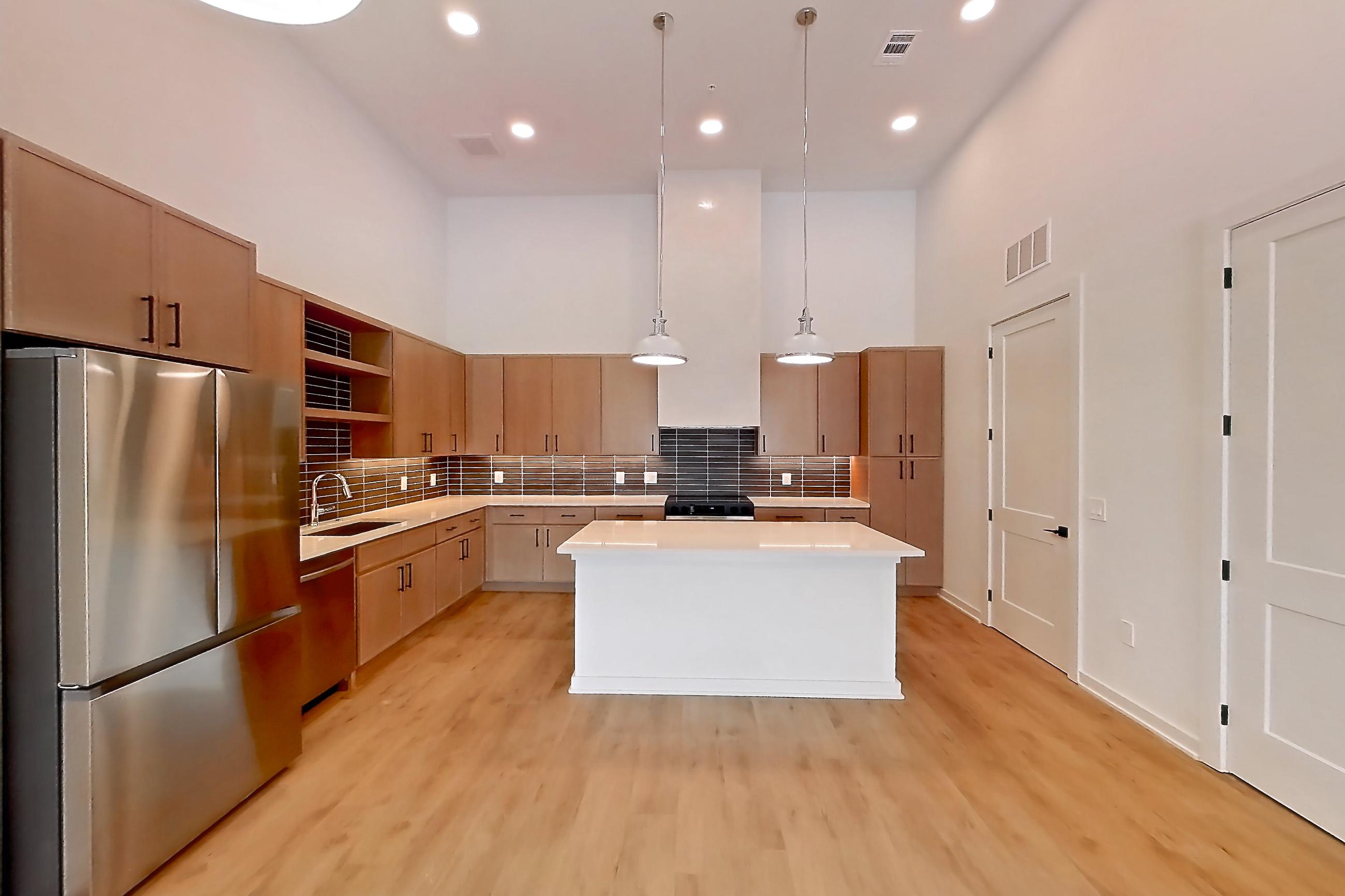 Dining room with black appliances, electric range, light countertops, light wood-finish flooring, oven/range, refrigerator, and stainless steel appliances, Apartment 1111 at Cortland Galleria