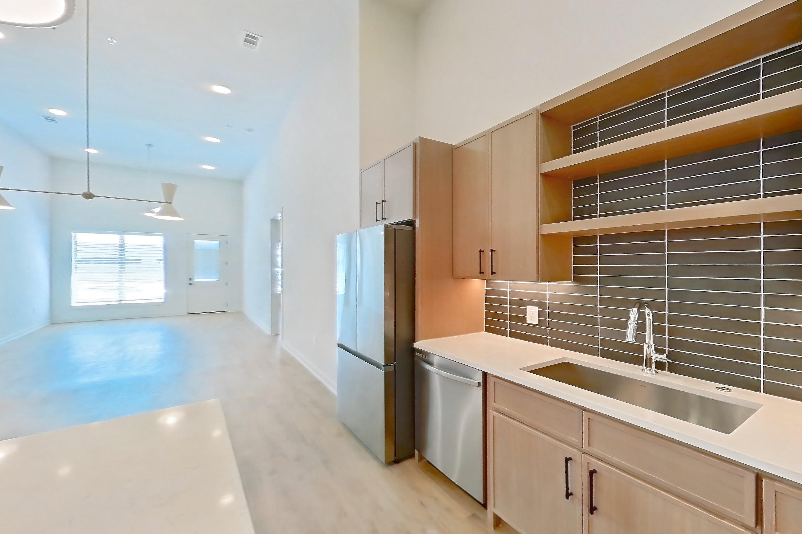 Kitchen with dishwasher, electric range, light countertops, light stone countertops, light wood-finish flooring, oven/range, refrigerator, and stainless steel appliances, Apartment 1111 at Cortland Galleria