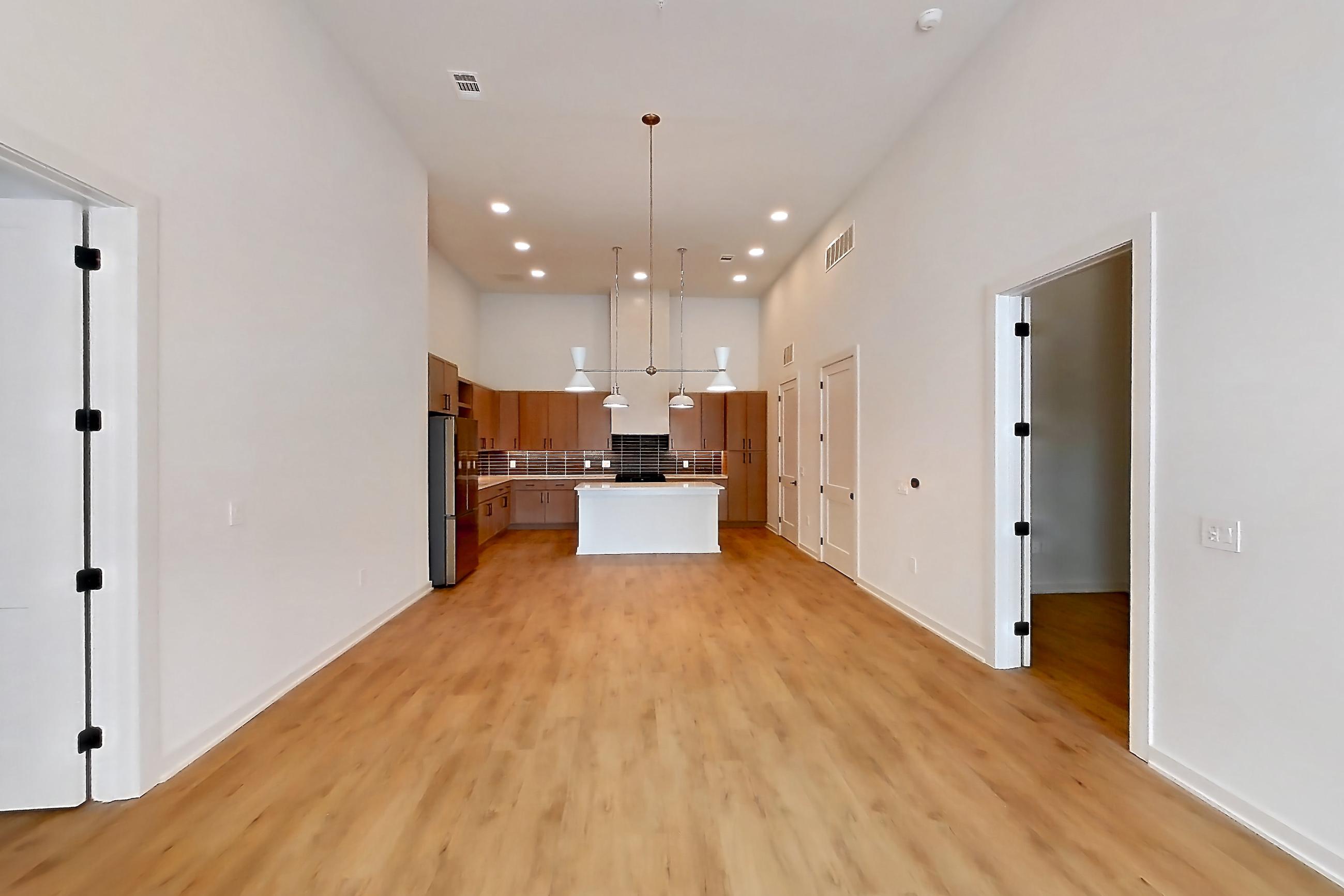 Living room with light countertops, light wood-finish flooring, refrigerator, and stainless steel appliances, Apartment 1111 at Cortland Galleria