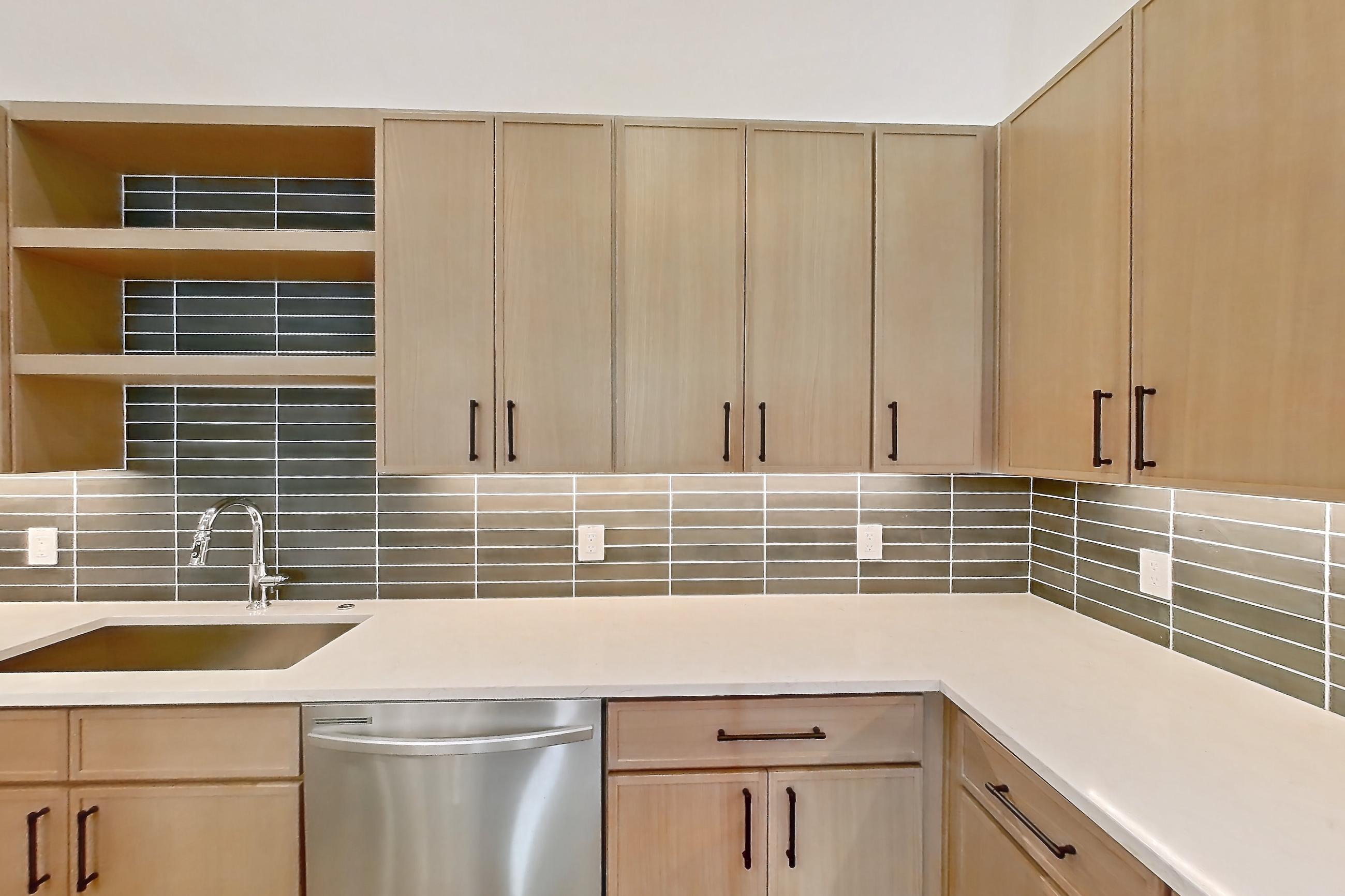 Kitchen with cooktop, dishwasher, electric cooktop, light countertops, light stone countertops, light wood-finish flooring, and stainless steel appliances, Apartment 1114 at Cortland Galleria