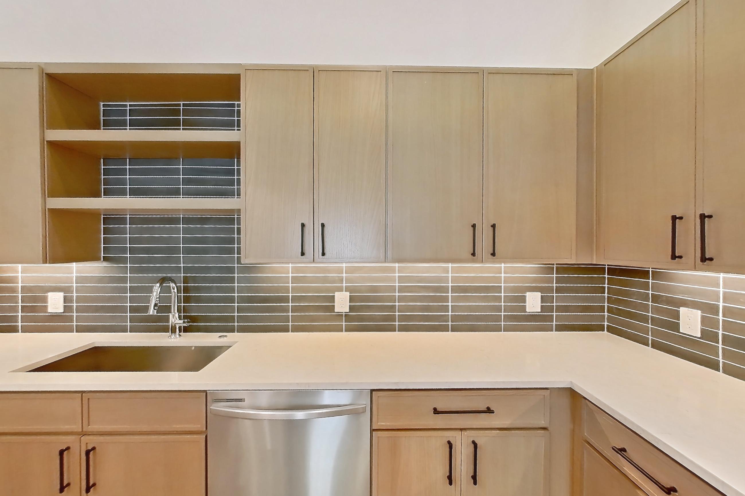 Kitchen with dishwasher, electric range, light stone countertops, light wood-finish flooring, oven/range, and stainless steel appliances, Apartment 1112 at Cortland Galleria