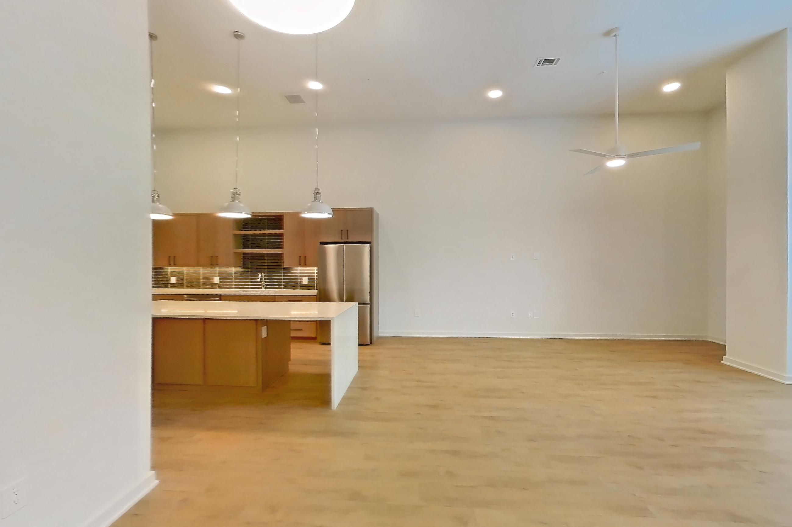 Dining room with light stone countertops, light wood-finish flooring, refrigerator, and stainless steel appliances, Apartment 1107 at Cortland Galleria