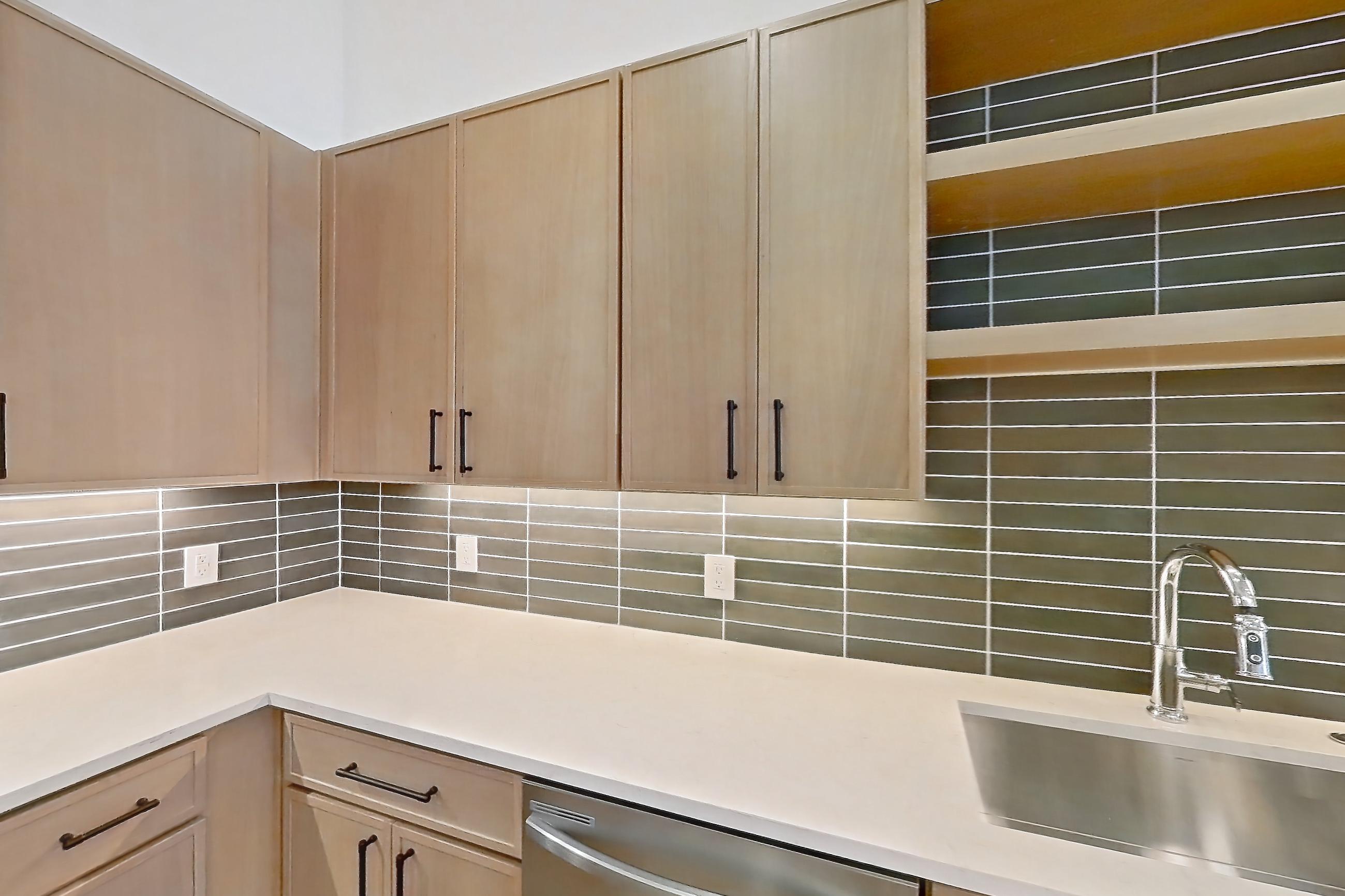 Kitchen with dishwasher, electric range, light stone countertops, light wood-finish flooring, oven/range, and stainless steel appliances, Apartment 1107 at Cortland Galleria