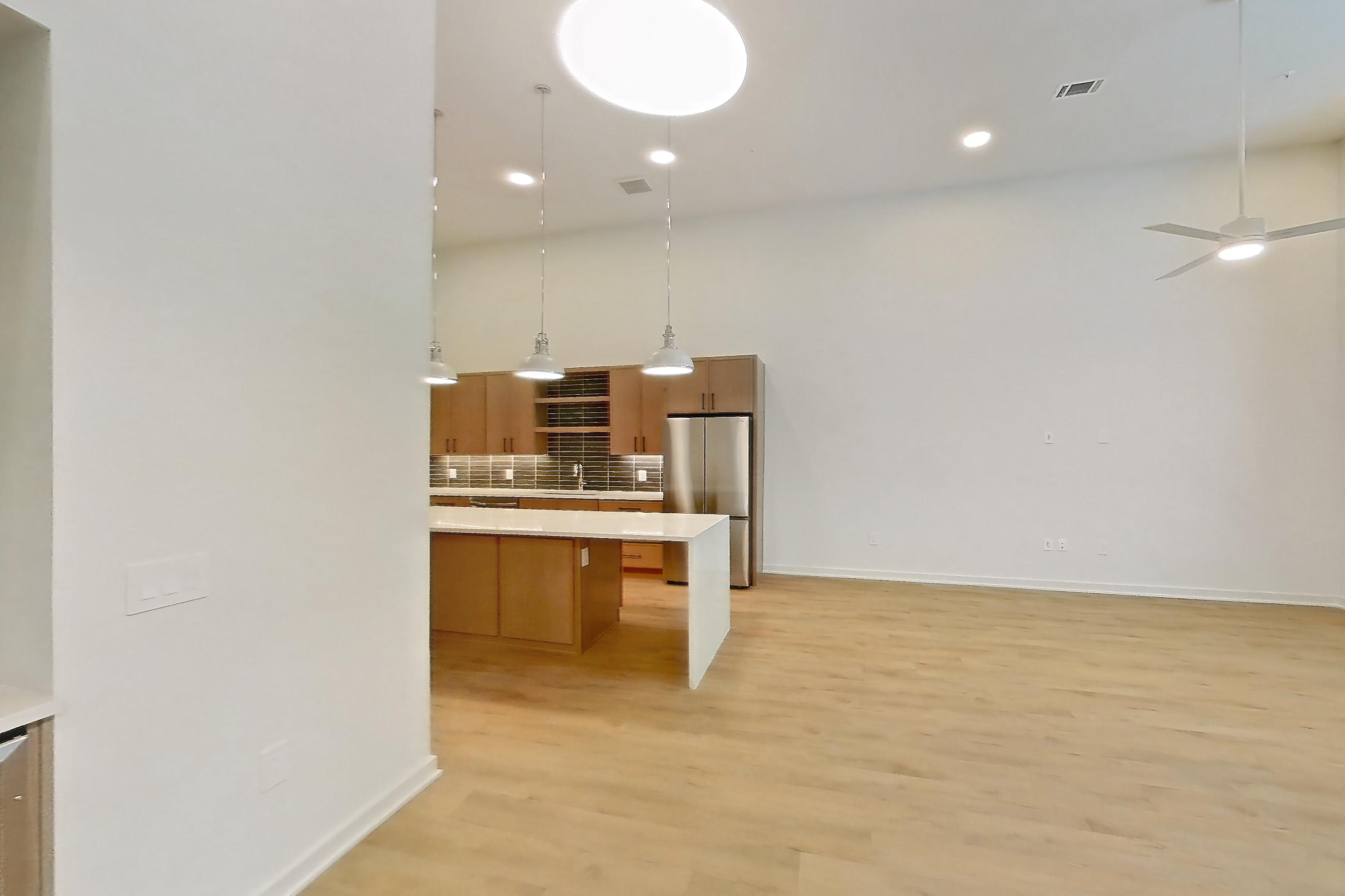 Dining room with light stone countertops, light wood-finish flooring, refrigerator, and stainless steel appliances, Apartment 1108 at Cortland Galleria