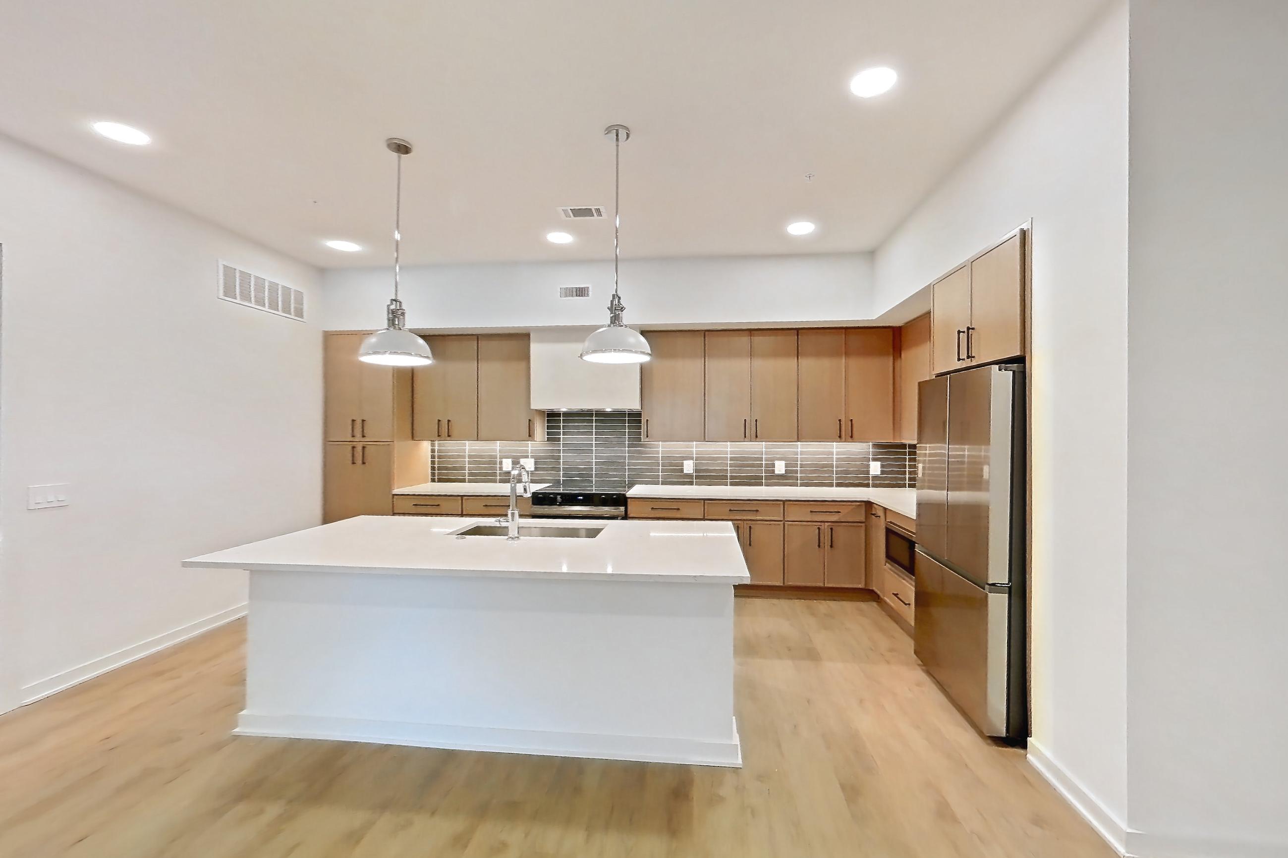 Dining room with electric range, kitchen island, light countertops, light wood-finish flooring, oven/range, and stainless steel appliances, Apartment 1103 at Cortland Galleria