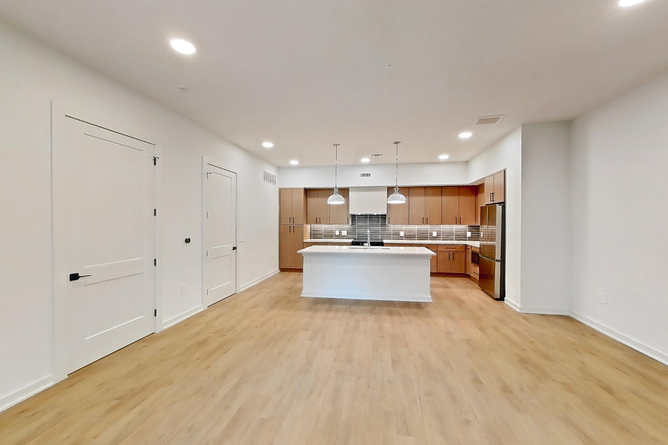 Living room with kitchen island, light countertops, and light wood-finish flooring, Apartment 1103 at Cortland Galleria