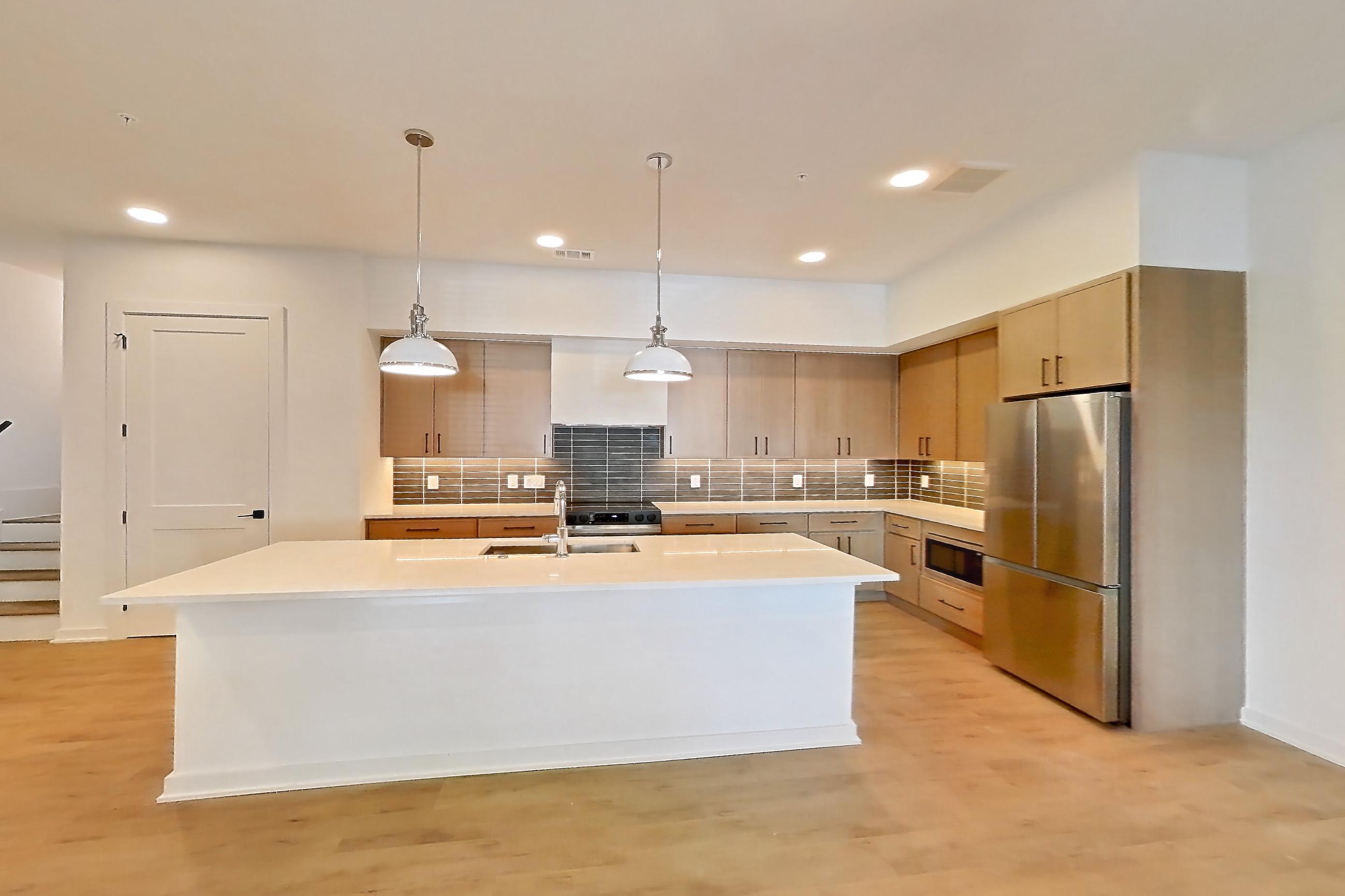 Dining room with built-in microwave, electric range, light countertops, light wood-finish flooring, oven/range, refrigerator, and stainless steel appliances, Apartment 1101 at Cortland Galleria