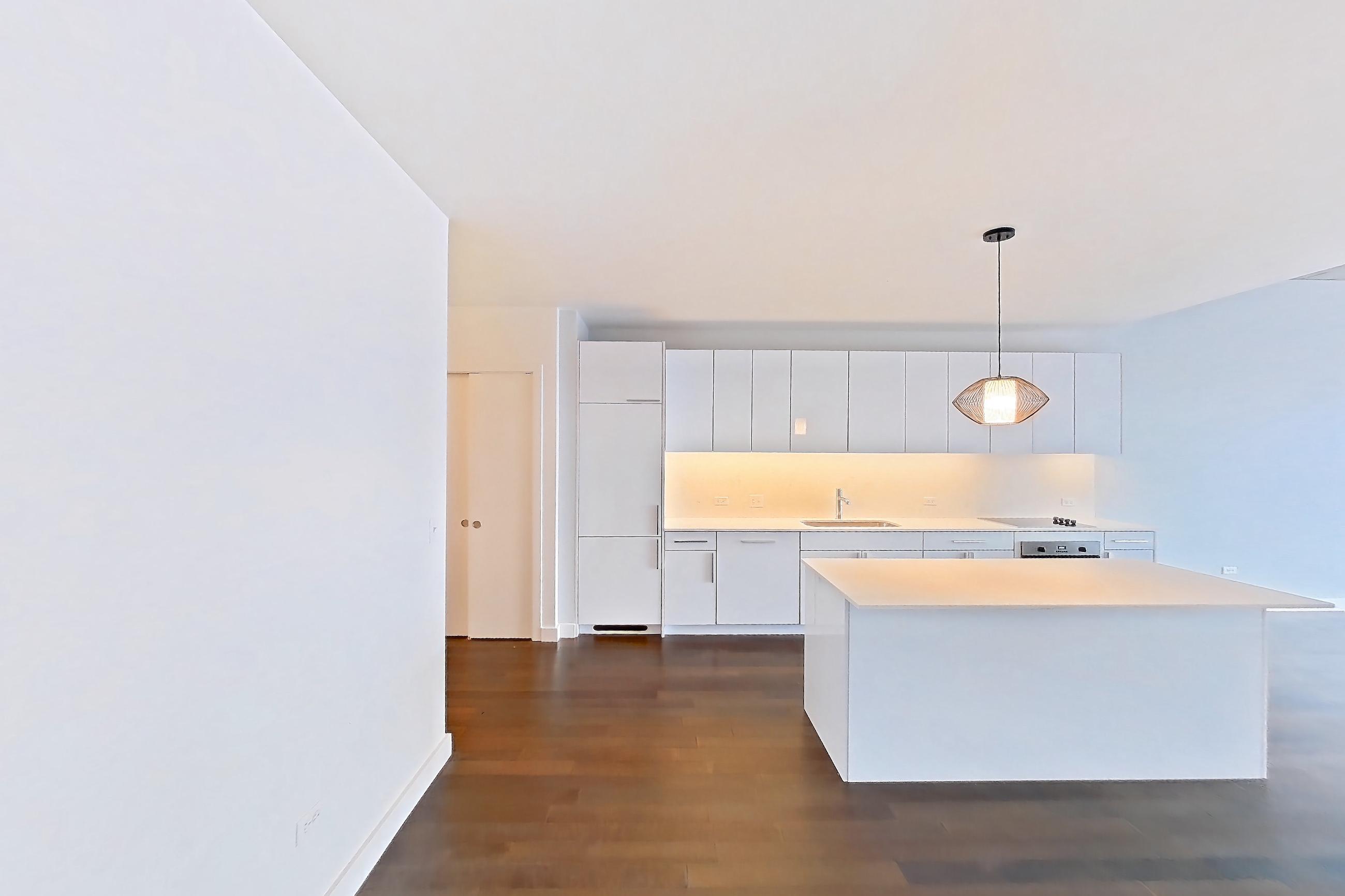 Living space with black appliances, cooktop, dark wood-finish flooring, electric cooktop, light countertops, refrigerator, and white appliances, Apartment 2507 at 220 WIL