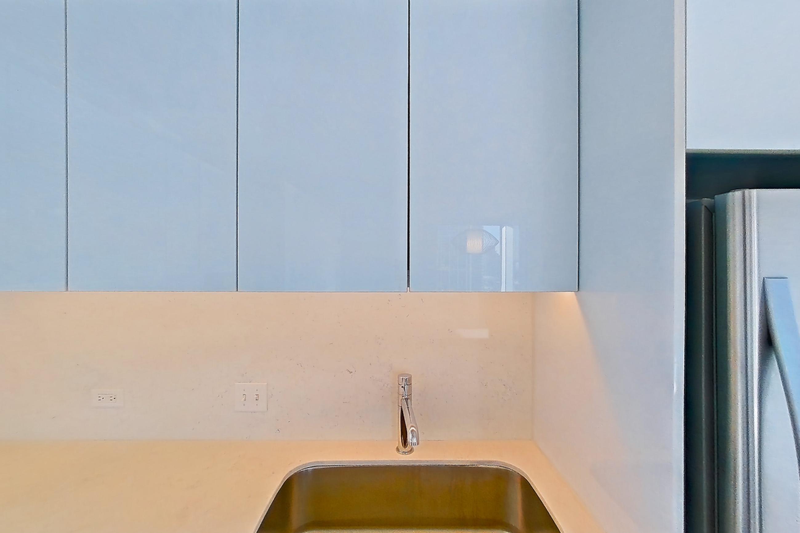 Kitchen with black appliances, cooktop, dark wood-finish flooring, electric cooktop, light stone countertops, light wood-finish flooring, oven/range, refrigerator, skyline view, and stainless steel appliances, Apartment 2302 at 220 WIL