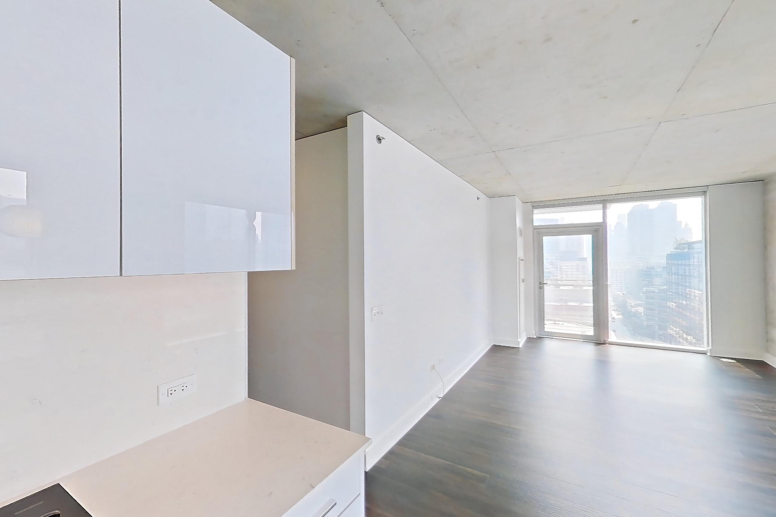 Kitchen with black appliances, cooktop, dark wood-finish flooring, electric cooktop, light stone countertops, oven/range, and stainless steel appliances, Apartment 1610 at 220 WIL