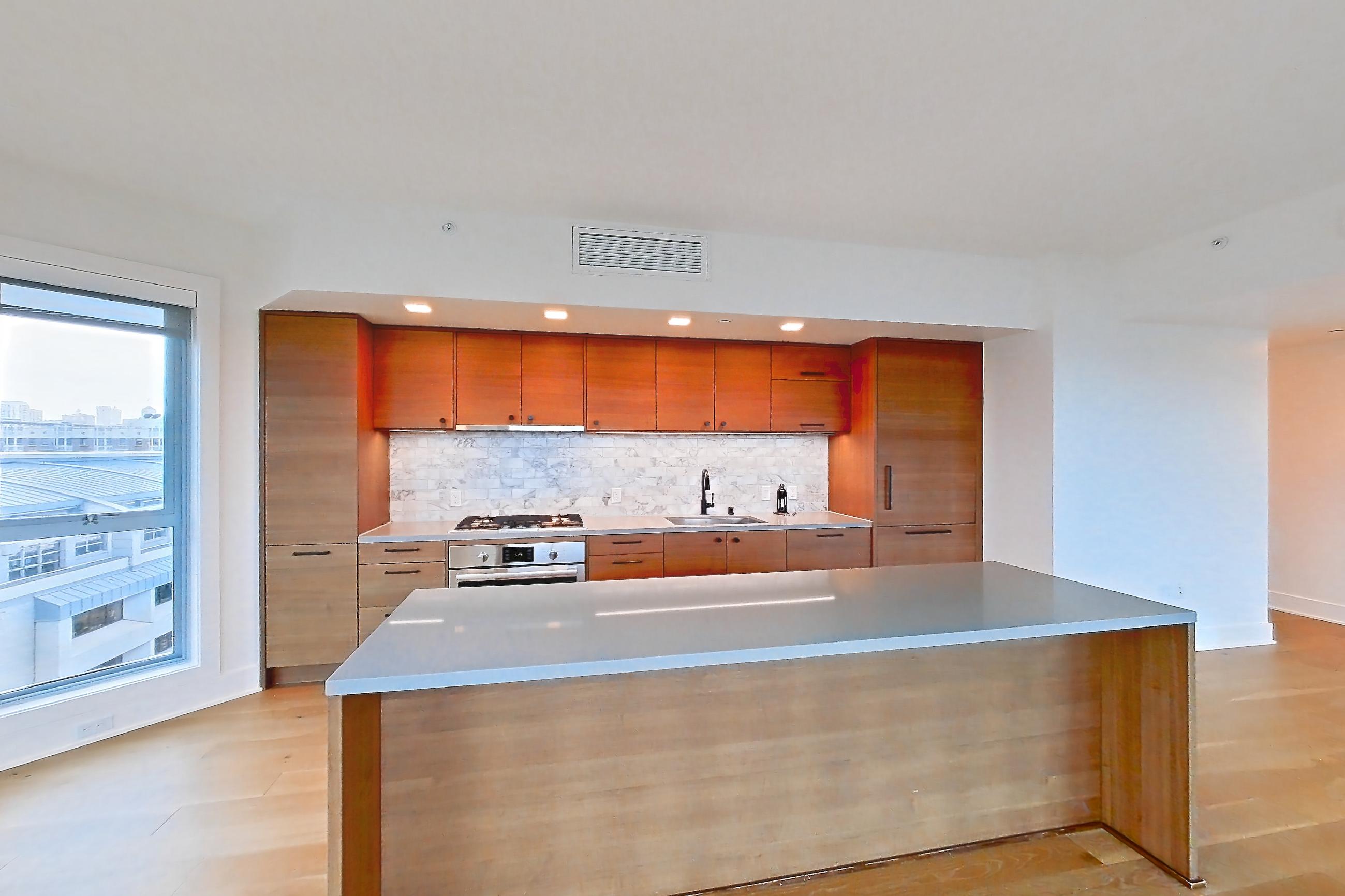 Dining room with cooktop, gas cooktop, light stone countertops, light wood-finish flooring, oven/range, stainless steel appliances, and wood-finish flooring, Apartment PH2 at Konrad on the Park