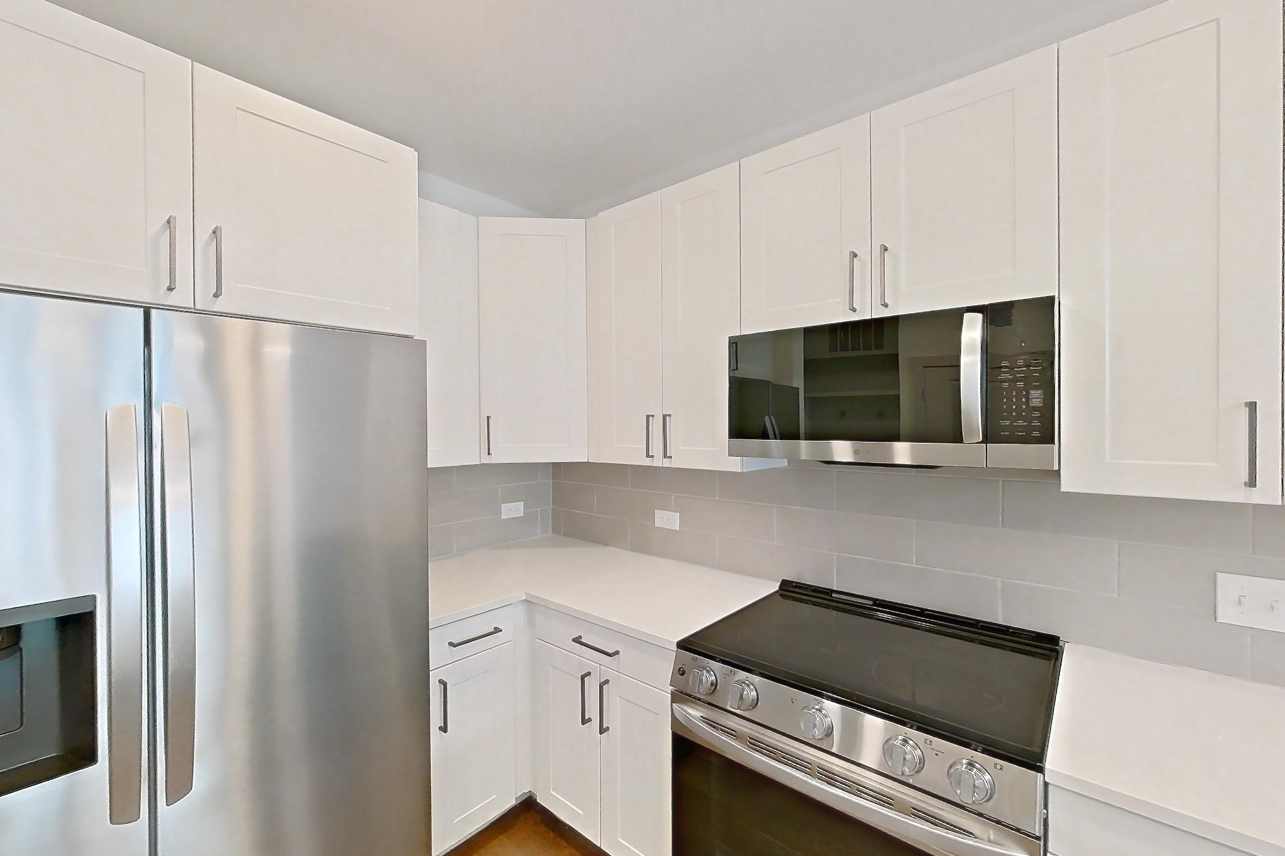 Kitchen with dark wood-finish flooring, dishwasher, electric range, light countertops, light stone countertops, light wood-finish flooring, oven/range, refrigerator, stainless steel appliances, and water & ice dispenser, Apartment 2305 at Groves South Congress