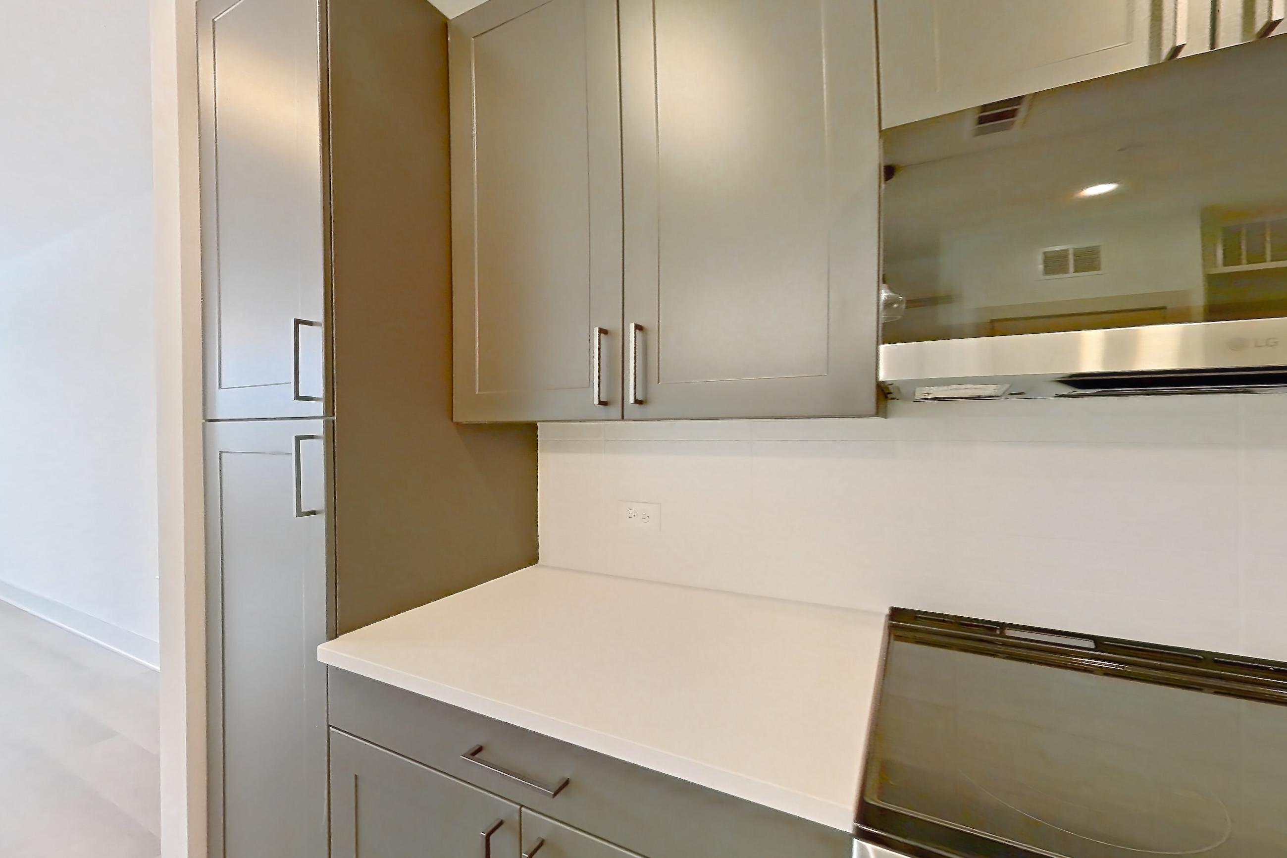 Kitchen with dishwasher, electric range, kitchen island, light countertops, light wood-finish flooring, oven/range, and stainless steel appliances, Apartment 2248 at Groves South Congress