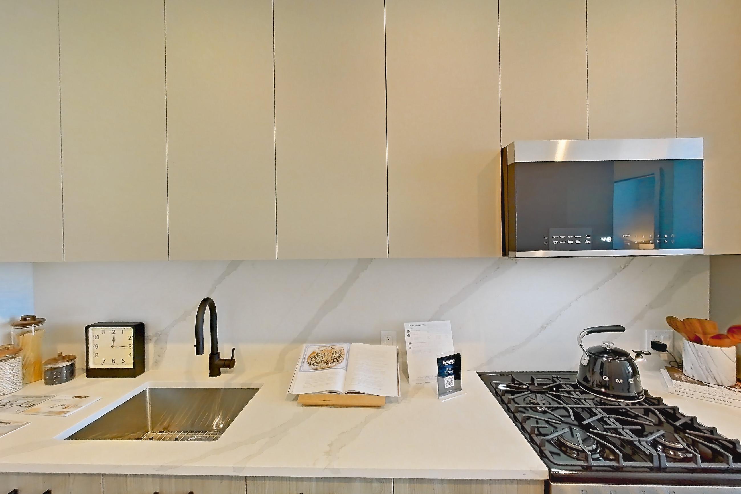 Kitchen with gas range, light stone countertops, light wood-finish flooring, oven/range, and stainless steel appliances, Apartment PH2G at Lumen