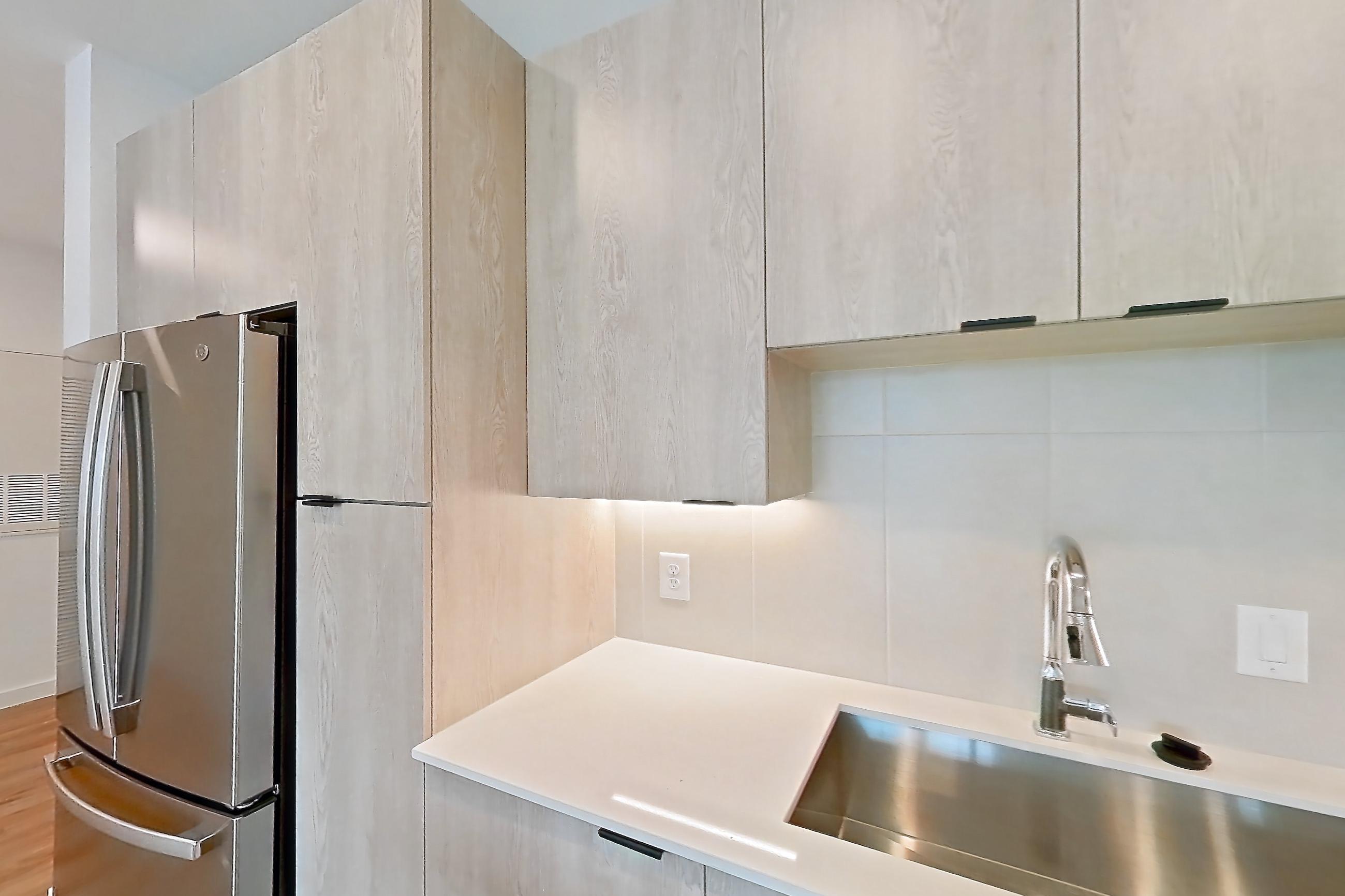 Kitchen with dishwasher, electric range, light countertops, light wood-finish flooring, microwave, oven/range, and stainless steel appliances, Apartment 1213 at Caroline Anclote Harbor
