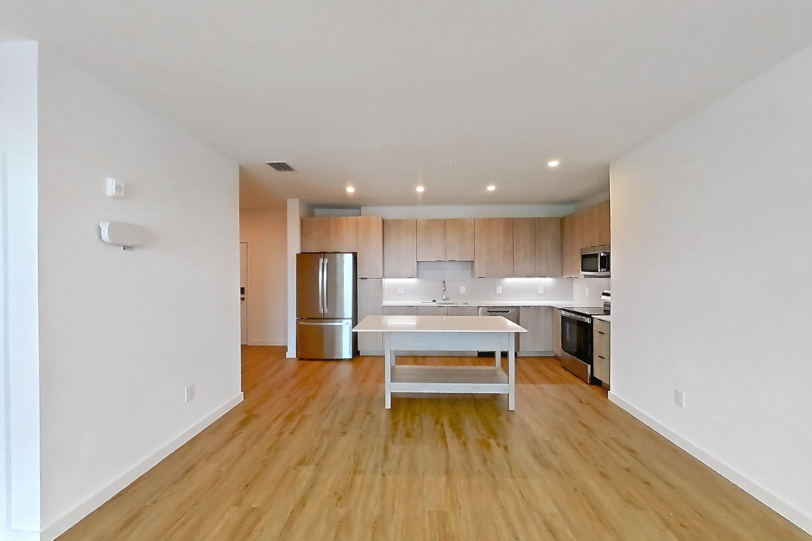 Living space with electric range, light countertops, light wood-finish flooring, oven/range, refrigerator, and stainless steel appliances, Apartment 1306 at Caroline Anclote Harbor