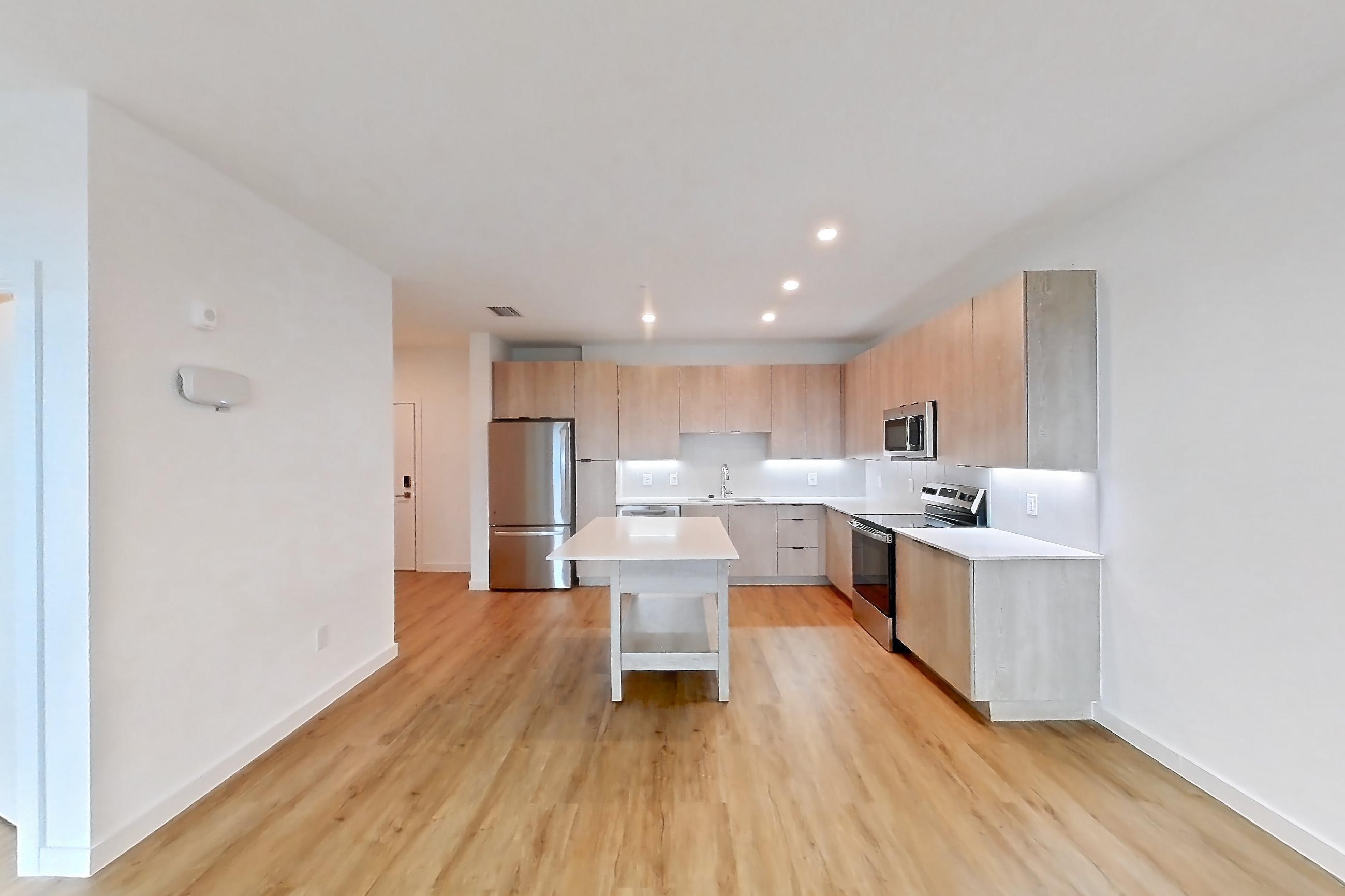Living space with dishwasher, electric range, light countertops, light wood-finish flooring, oven/range, refrigerator, and stainless steel appliances, Apartment 1414 at Caroline Anclote Harbor