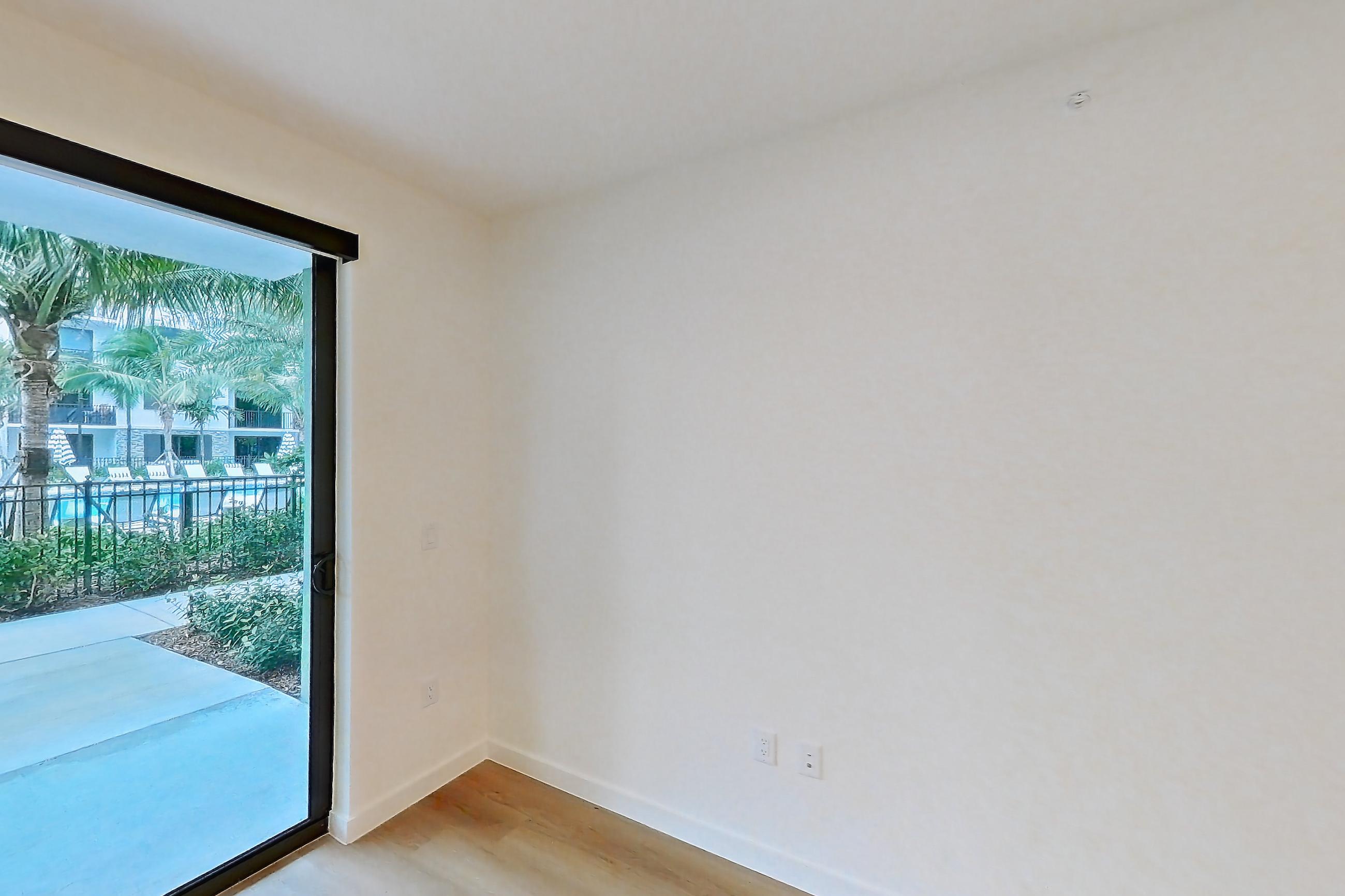 Living room with light wood-finish flooring, Apartment 102 at Caroline Pompano Beach