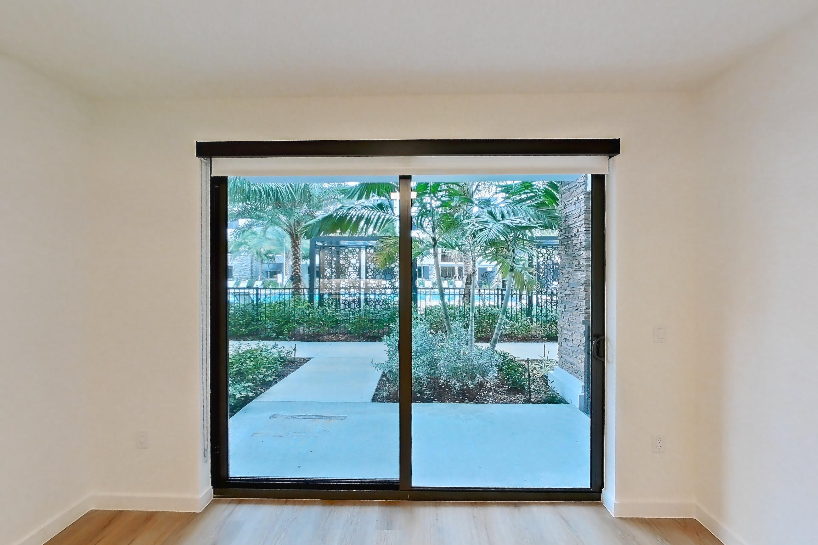 Living room with light wood-finish flooring, Apartment 103 at Caroline Pompano Beach