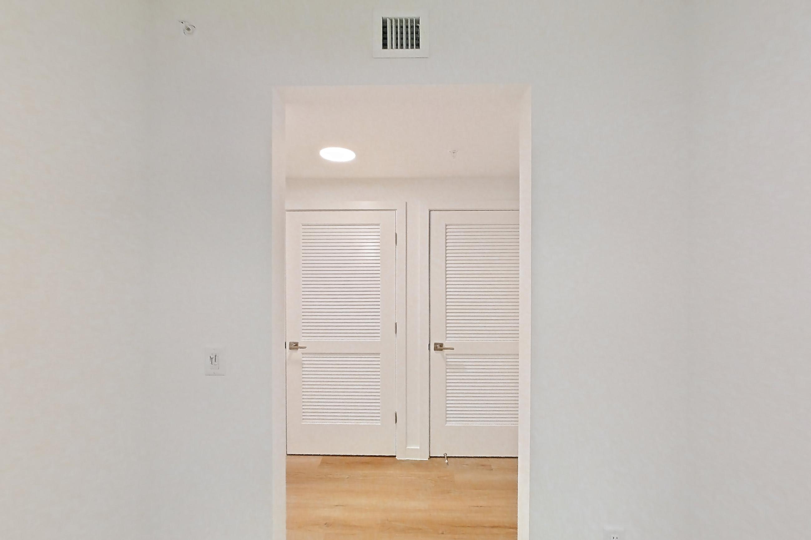 Entryway living space with light wood-finish flooring, Apartment 104 at Caroline Pompano Beach