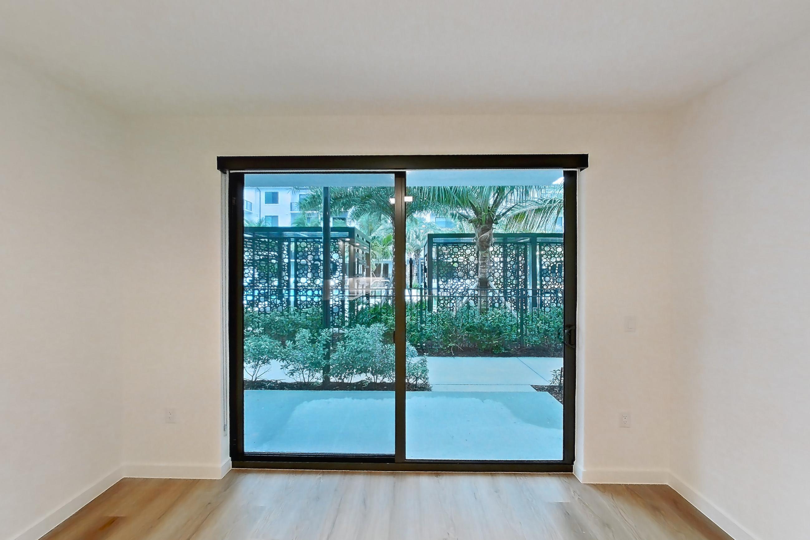 Living room with light wood-finish flooring, Apartment 104 at Caroline Pompano Beach