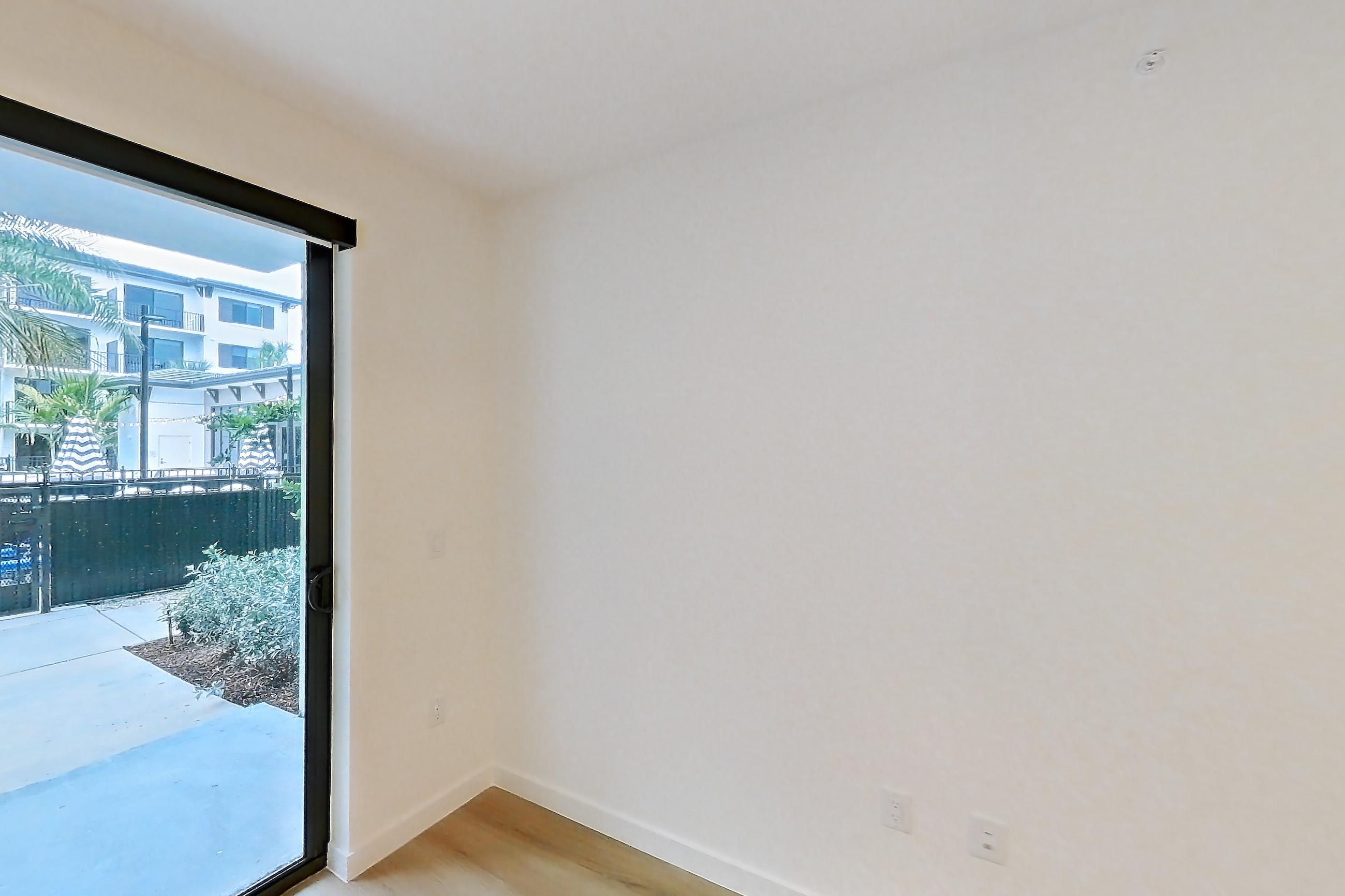 Living room with light wood-finish flooring, Apartment 105 at Caroline Pompano Beach