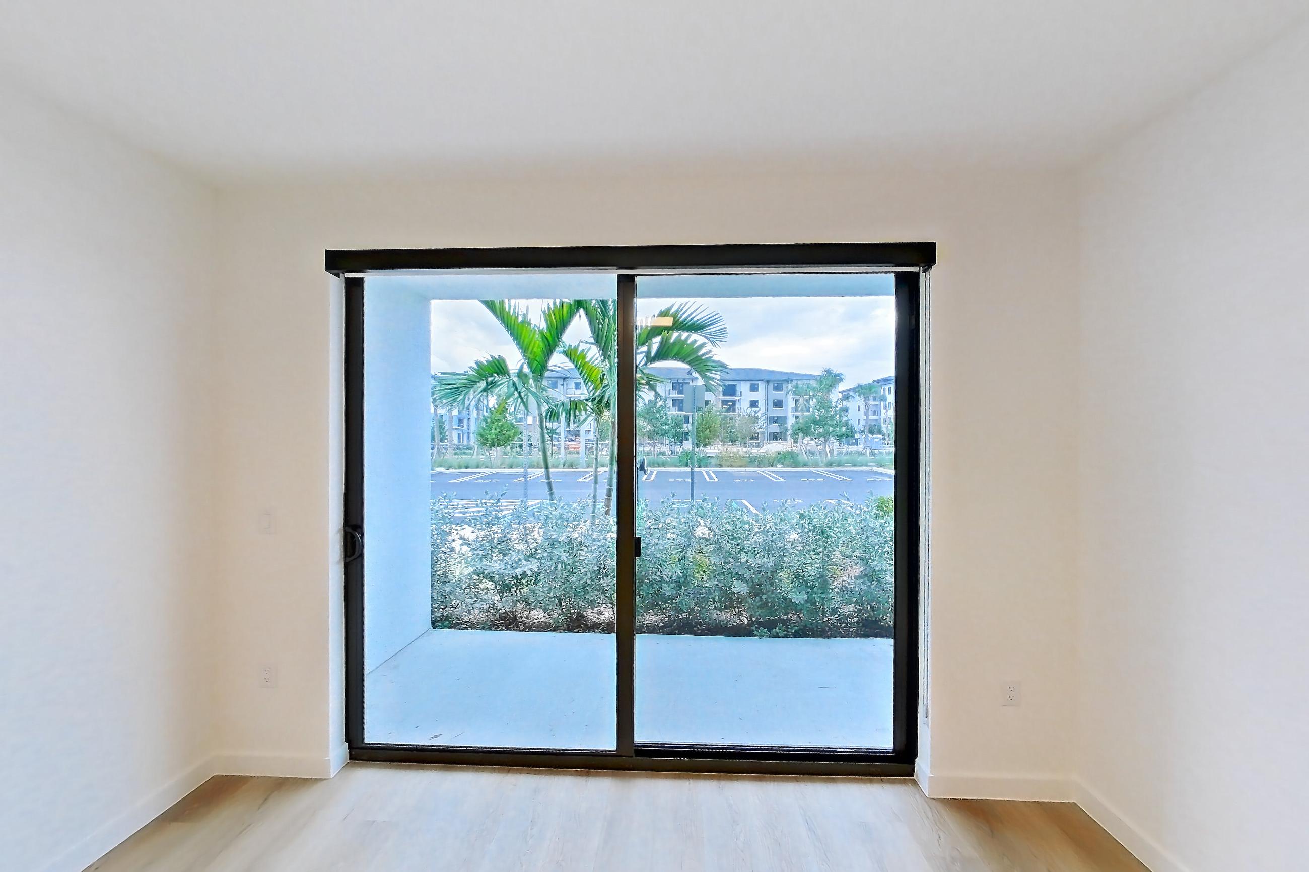 Living room with light wood-finish flooring, Apartment 107 at Caroline Pompano Beach