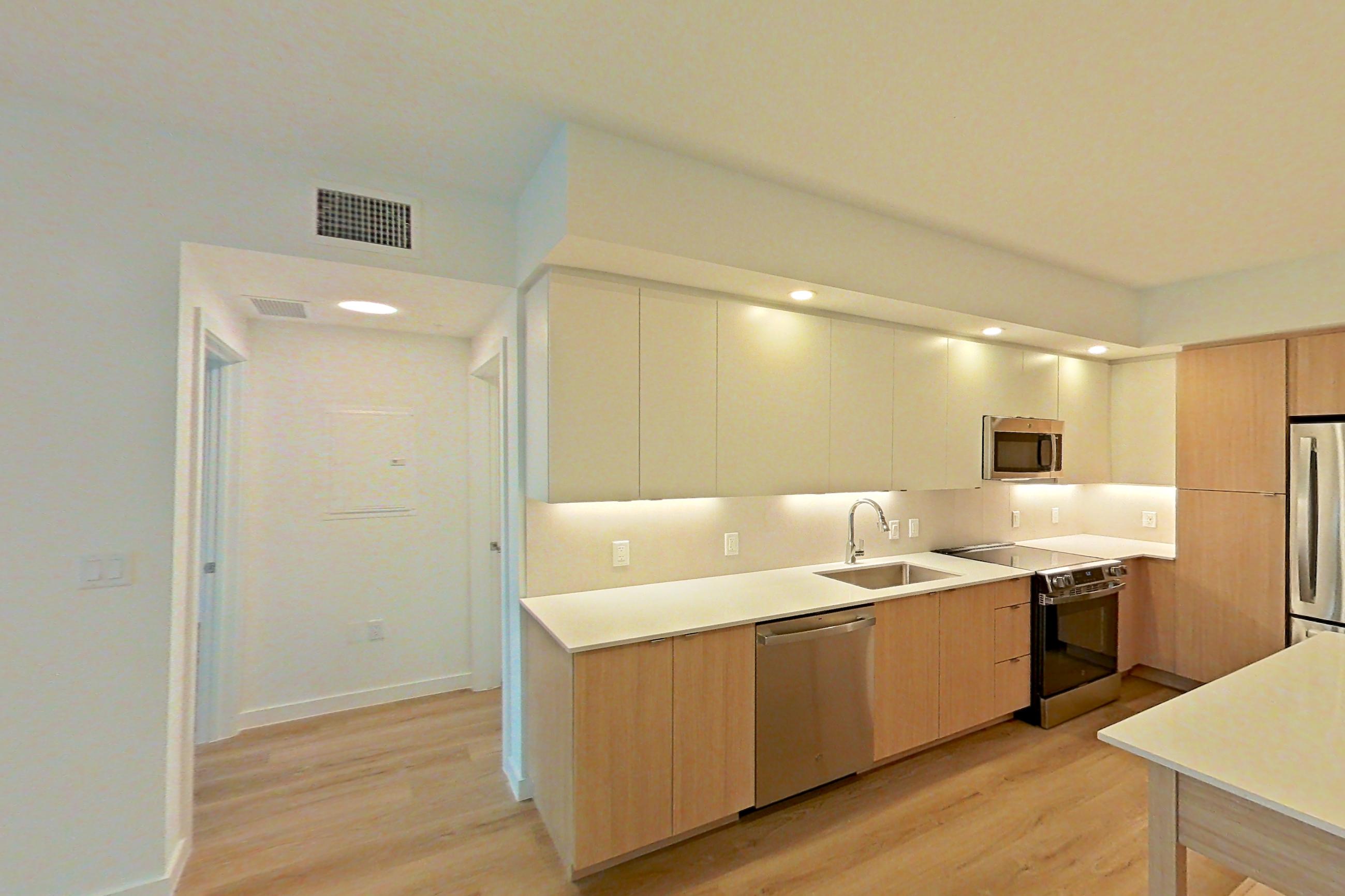 Living space with light countertops and light wood-finish flooring, Apartment 107 at Caroline Pompano Beach