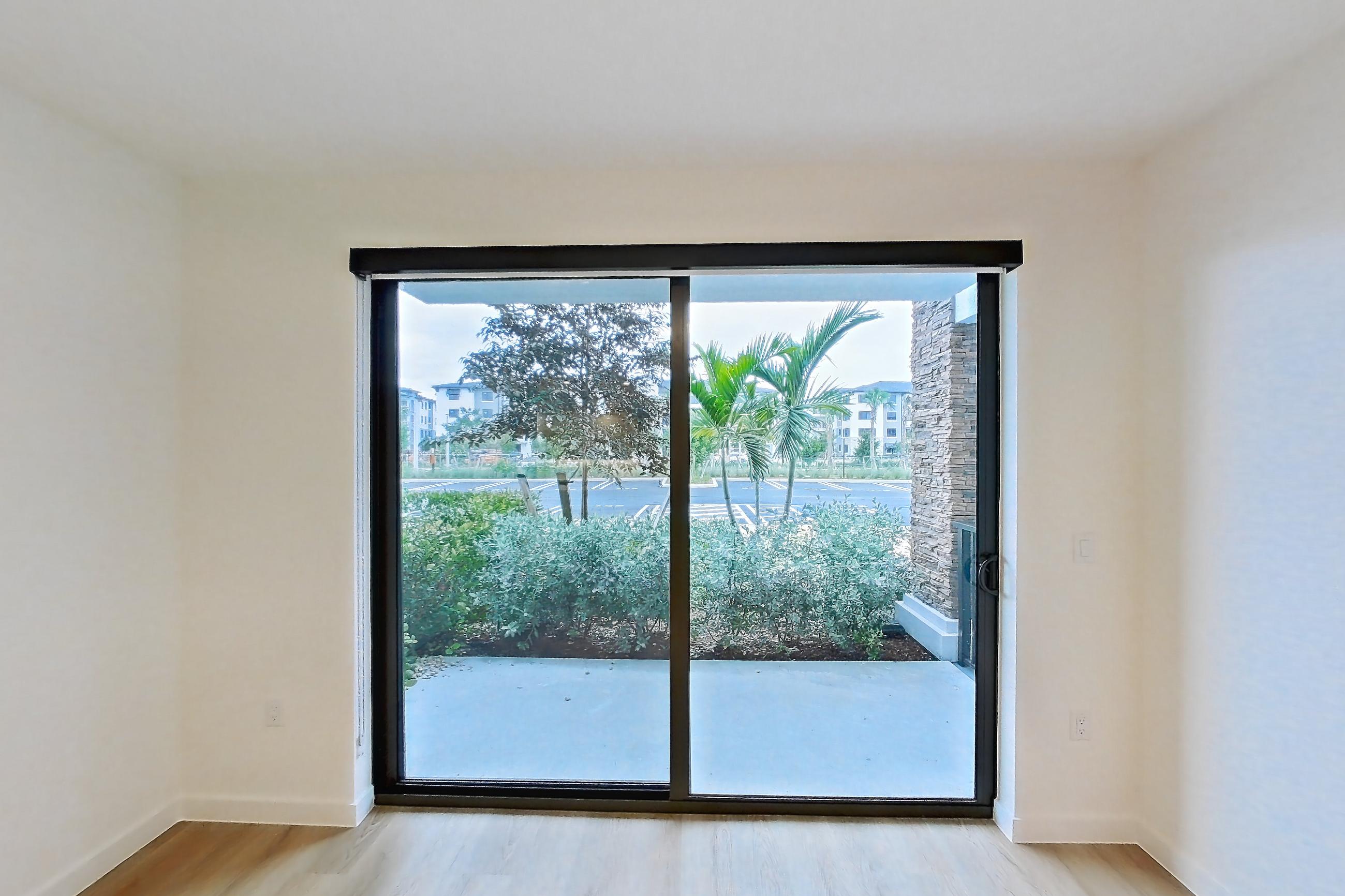 Living room with light wood-finish flooring, Apartment 108 at Caroline Pompano Beach