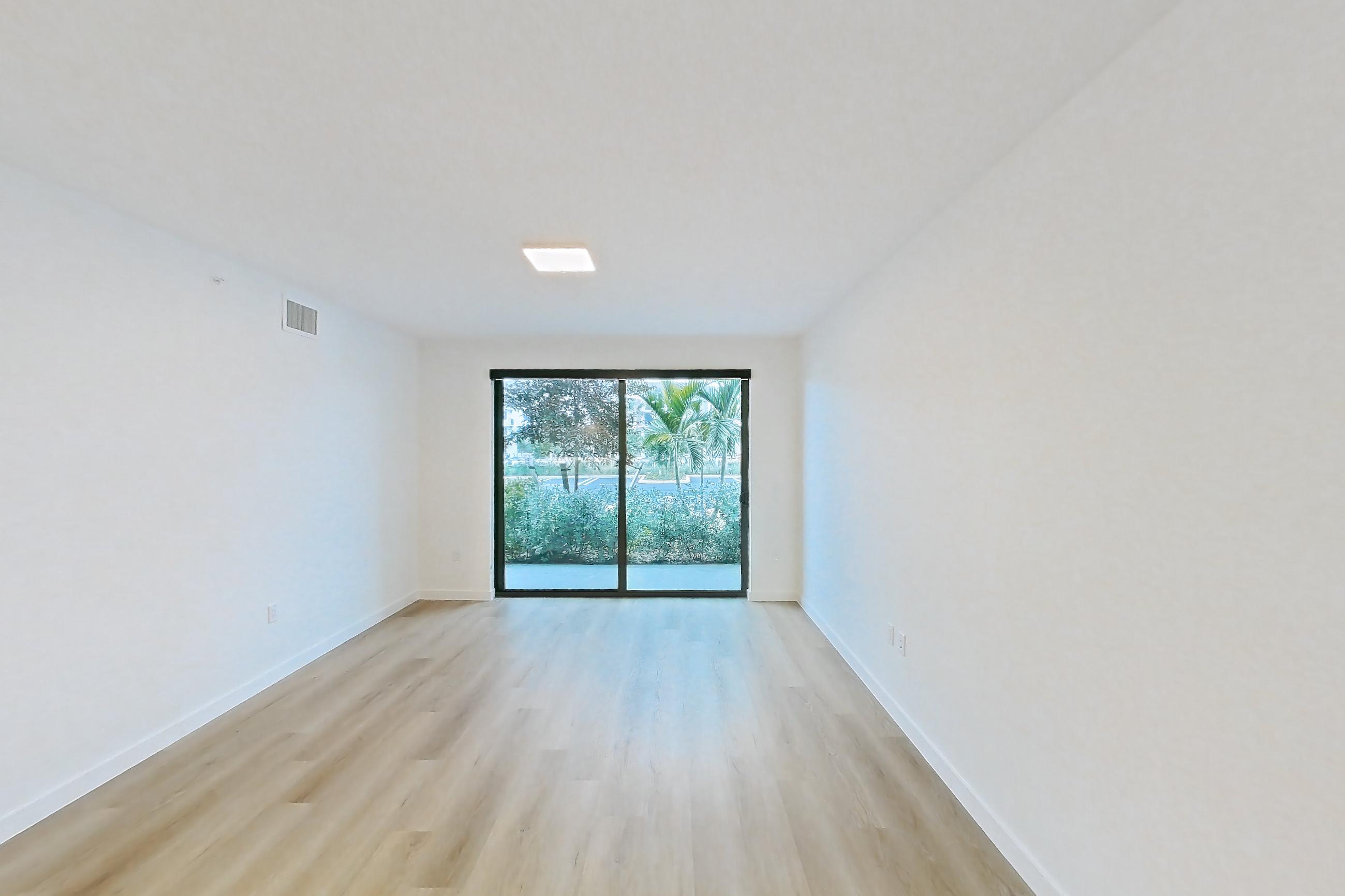 Living space with dishwasher, electric range, light countertops, light wood-finish flooring, oven/range, and stainless steel appliances, Apartment 108 at Caroline Pompano Beach