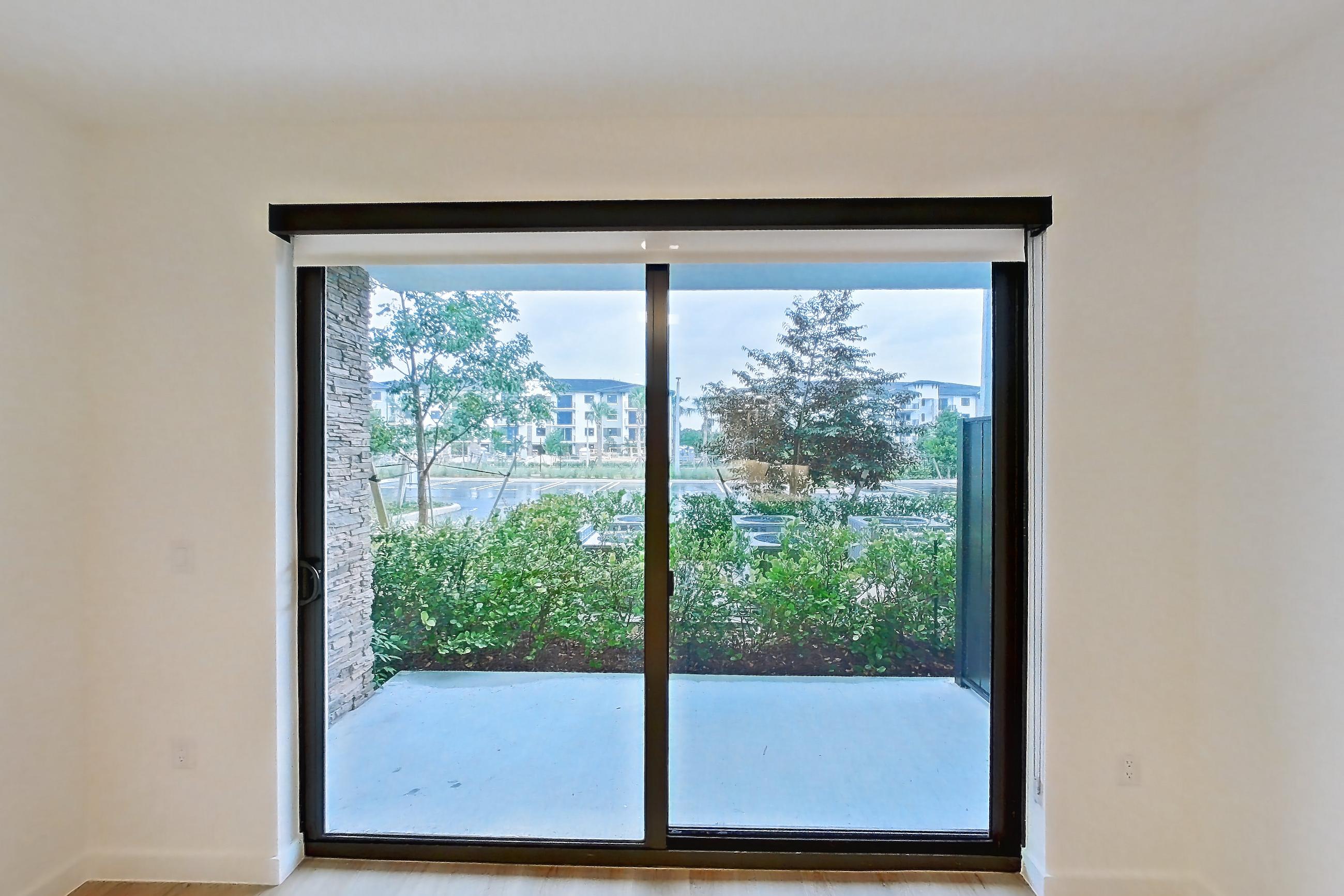 Living room with light wood-finish flooring, Apartment 110 at Caroline Pompano Beach