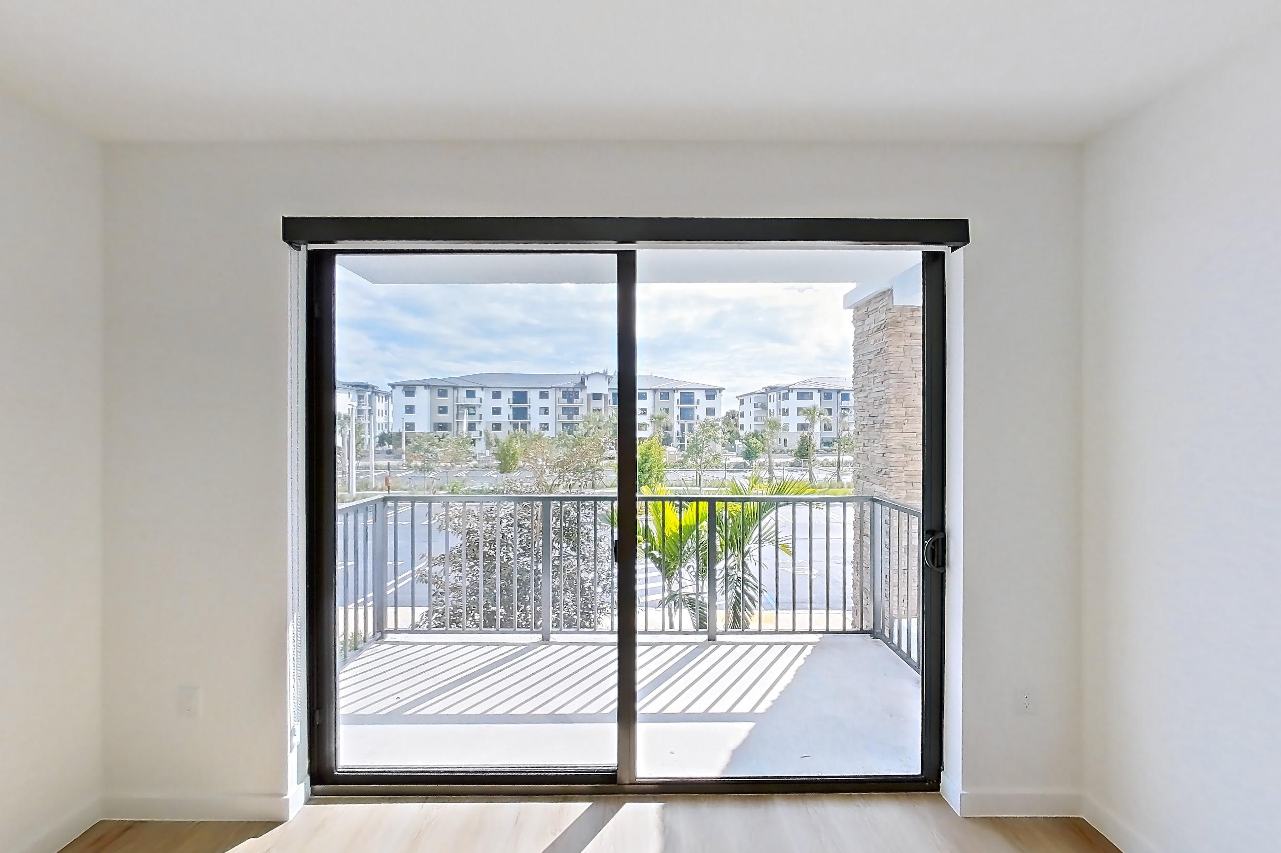 Living room with light wood-finish flooring, Apartment 208 at Caroline Pompano Beach